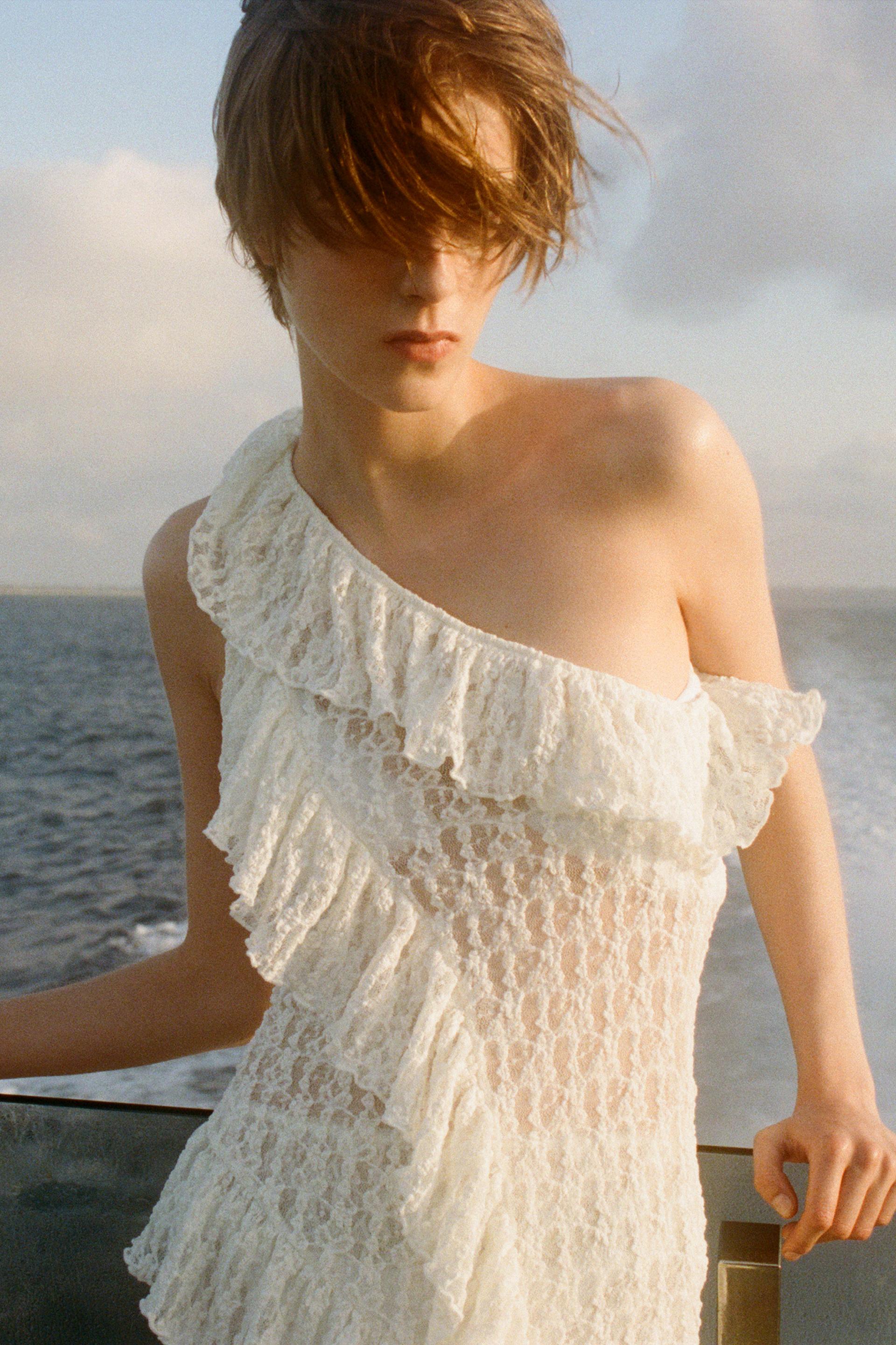 Elevate your wardrobe with the Asymmetric Lace Set, featuring a high-waisted semi-sheer long skirt that offers a comfortable fit with its elastic waistband. The semi-sheer top stands out with an asymmetric neckline and delicate ruffle detailing, adding a refined touch to the ensemble. This set balances elegance and subtle allure, perfect for sophisticated occasions where style and comfort are essential.