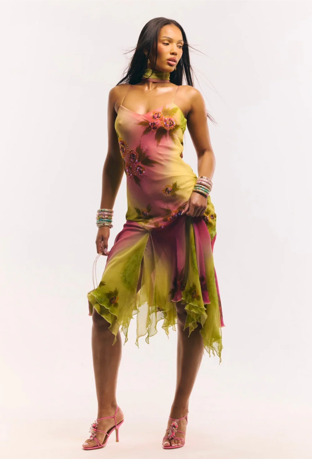 Crafted entirely by hand, the Coral Midi Dress showcases exquisite silk fabric detailed with intricate beadwork and custom floral embellishments in a captivating green and pink gradient watercolor. Its asymmetrical silhouette offers a unique, elegant shape that commands attention, making it a standout choice for refined occasions.