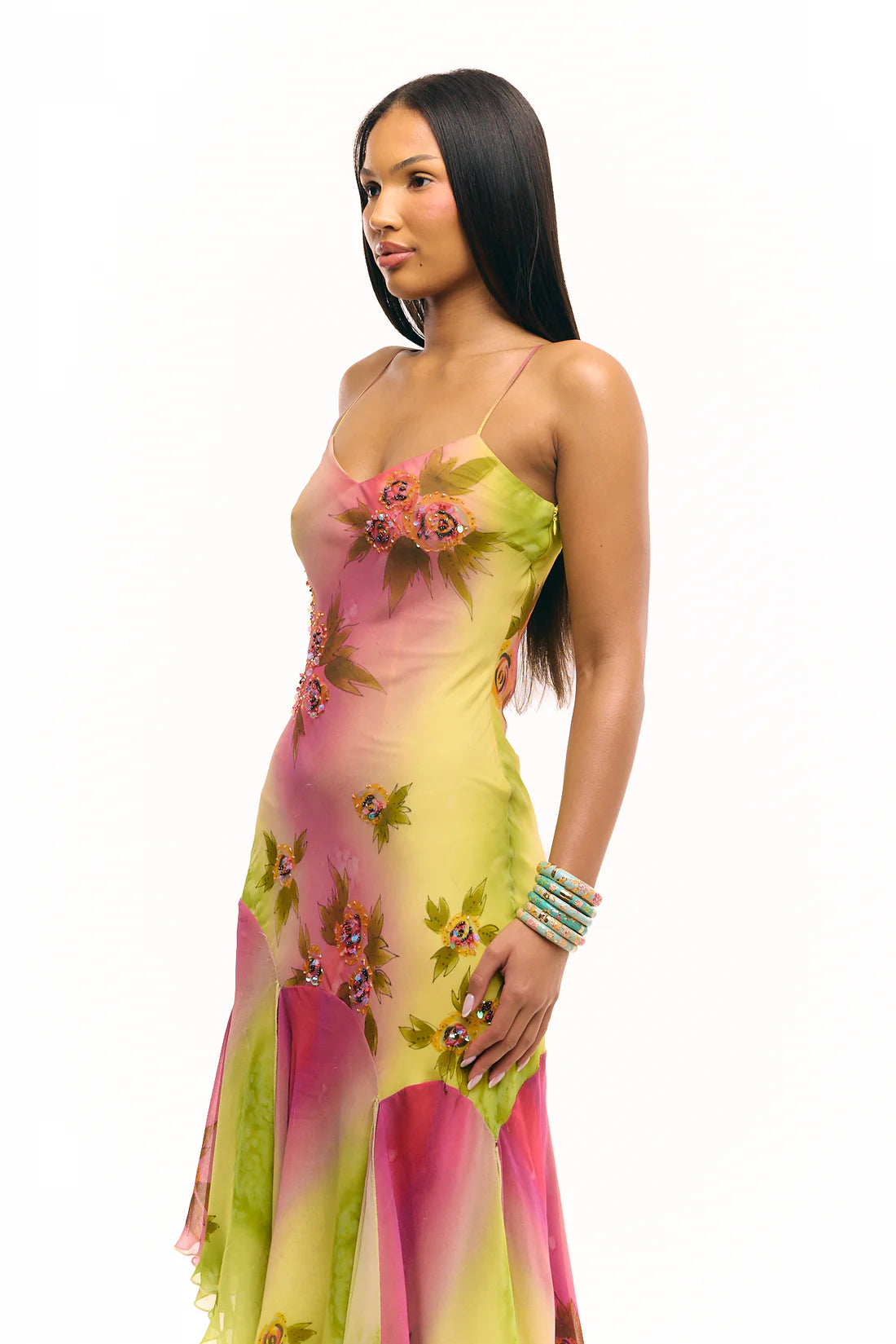 Crafted entirely by hand, the Coral Midi Dress showcases exquisite silk fabric detailed with intricate beadwork and custom floral embellishments in a captivating green and pink gradient watercolor. Its asymmetrical silhouette offers a unique, elegant shape that commands attention, making it a standout choice for refined occasions.