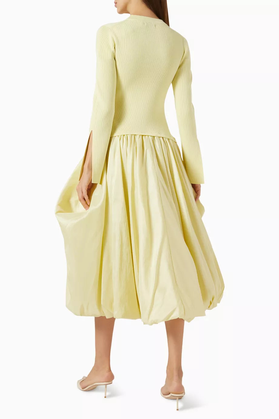 The Kenlie Midi Dress in Rayon Blend by Simkhai offers a sleek minimalist design that expertly enhances your silhouette. Its stretchy knit top contours comfortably, while the A-line skirt creates an elegant hourglass shape. Versatile by nature, this dress seamlessly transitions from casual to refined occasions, delivering both comfort and sophistication with ease.