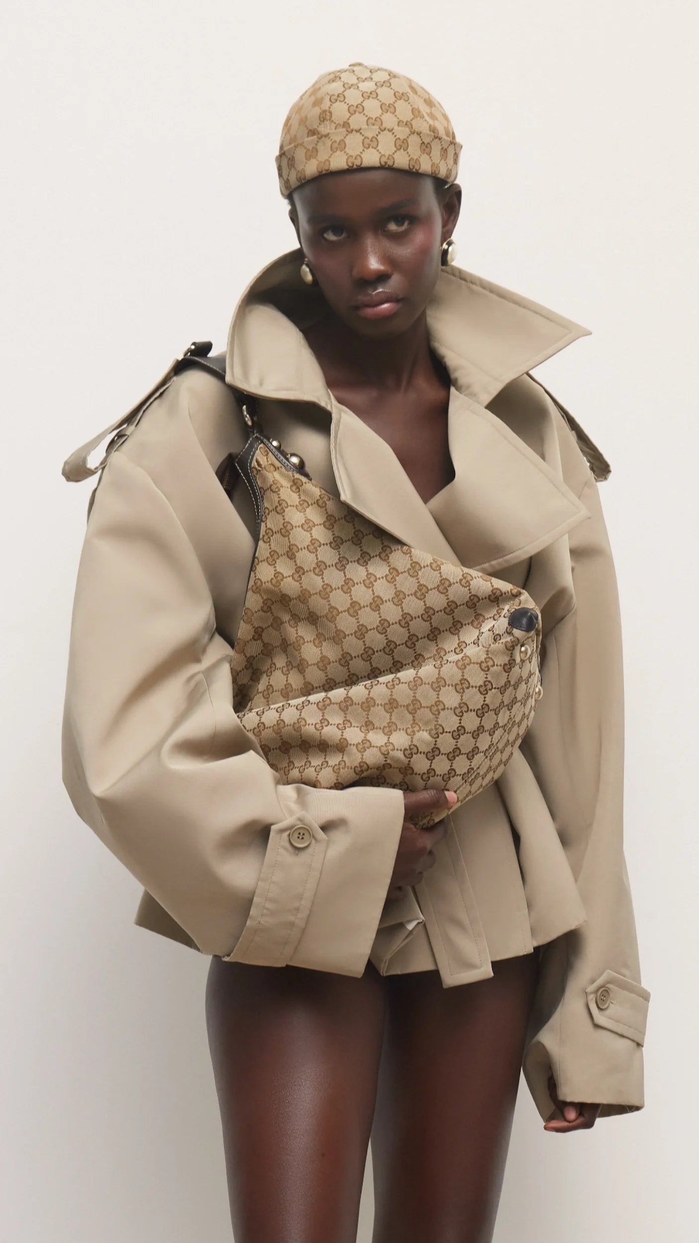 Elevate your wardrobe with this expertly tailored beige trench coat, offering a refined blend of classic design and contemporary appeal. The cropped silhouette enhances layering options, while the neutral beige shade ensures seamless coordination with varied outfits. Crafted for both comfort and style, this trench coat delivers a polished, sophisticated look that adapts effortlessly to different occasions. A versatile essential for a modern, elegant wardrobe.