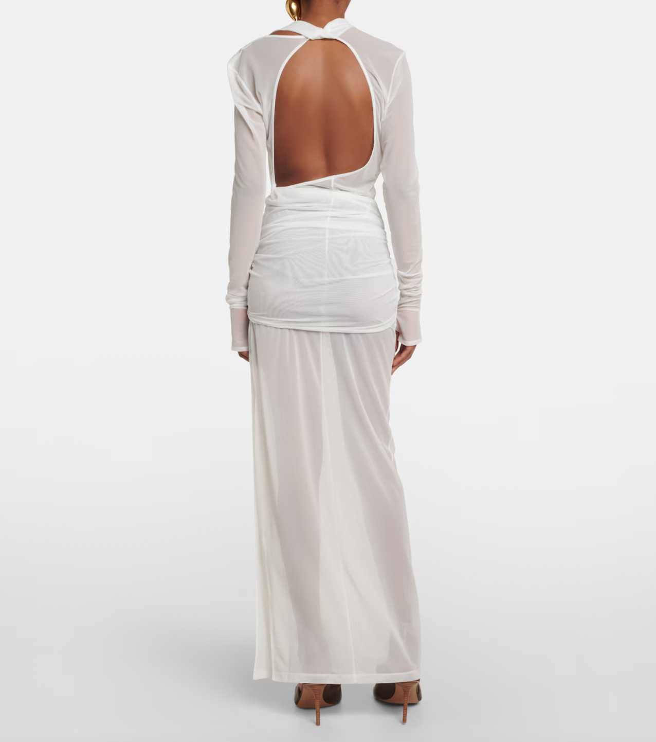 The La Robe Piombone tulle maxi dress by Jacquemus showcases a refined sheer tulle construction with a draped, full-length silhouette that elegantly contours the body. Its asymmetric neckline adds a modern architectural touch, while the long sleeves with thumb holes provide subtle coverage and a distinctive detail. The high-cut side slit enhances movement and introduces a sensual element, making this dress a sophisticated statement for formal occasions or avant-garde styling.