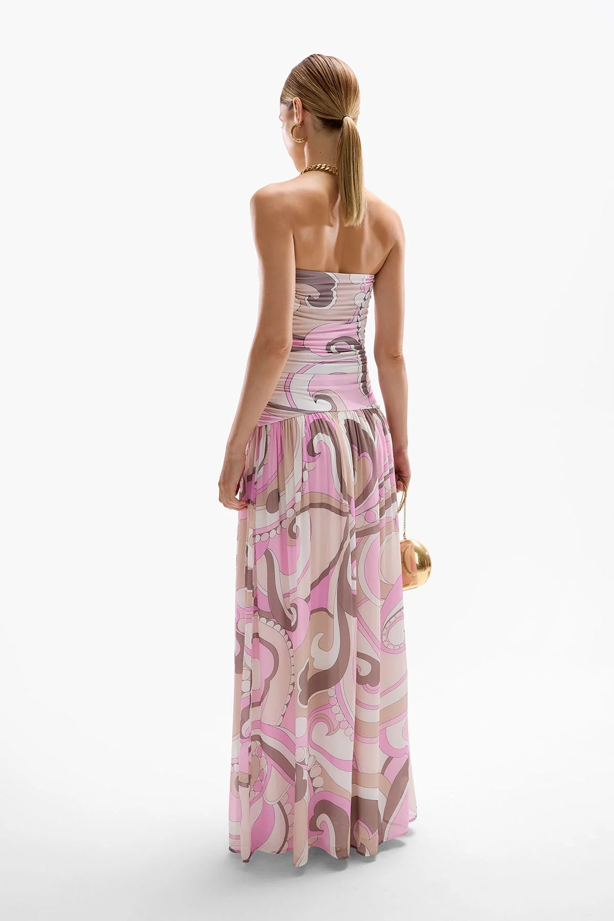 The Antibes Maxi Dress showcases a sophisticated drop-waist silhouette enhanced by subtle ruching along the side seams, creating a flattering, elegant fit. Its Dolce Pink palette blends cool berry tones with deep browns in fluid, swirling patterns that capture the essence of a vibrant seventies jet set aesthetic. Perfect for making a stylish statement, this dress combines timeless design with contemporary flair for a standout look.