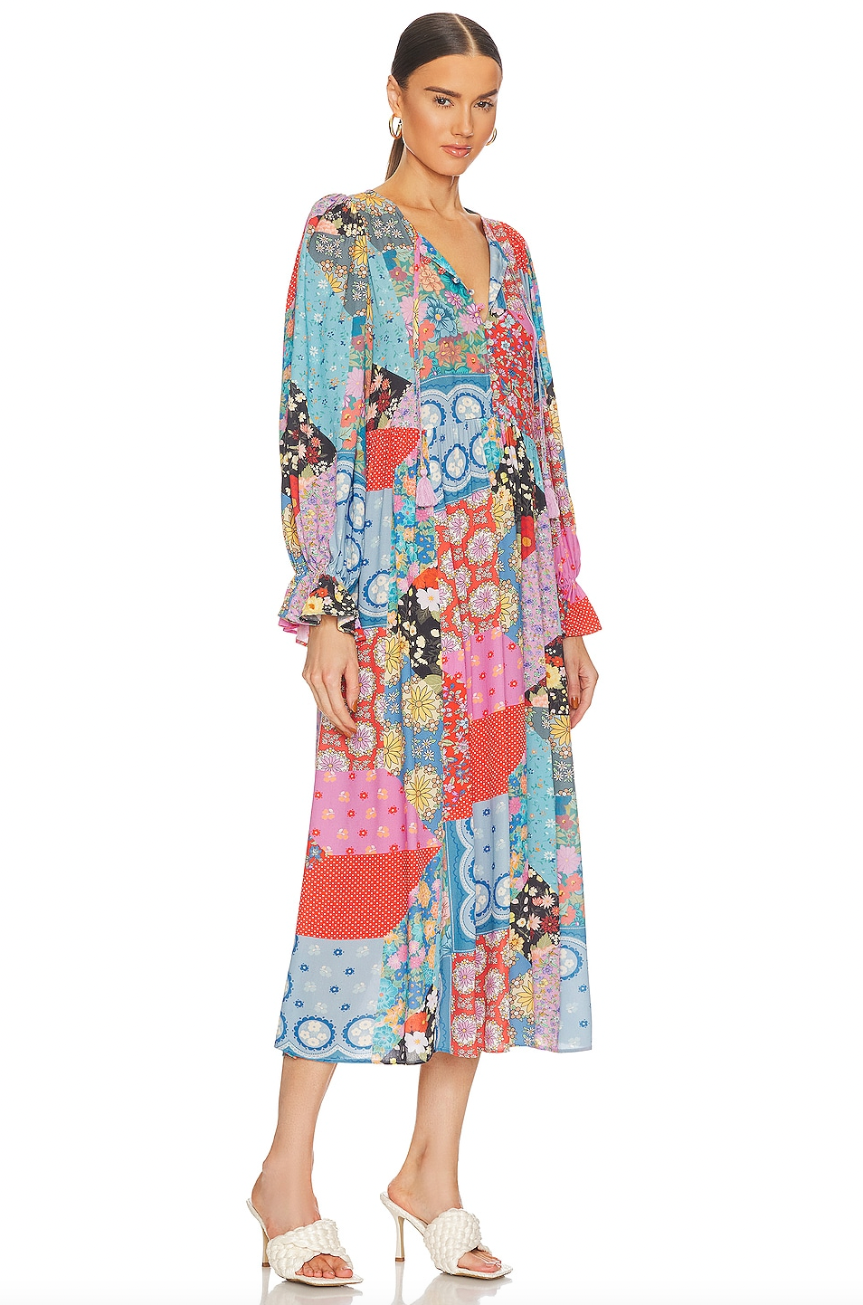 The Cha Cha Boho Midi Dress by Spell offers effortless style with its unlined, lightweight, and airy fabric, perfect for warm weather. It features a convenient pull-on design complemented by a partial front button closure for easy wear. The tie detail at the neckline with tasseled ends adds a delicate bohemian touch, while the cinched ruffled cuffs enhance the dress's feminine silhouette. This dress blends comfort and sophisticated design, ideal for those seeking a breathable, stylish wardrobe staple.