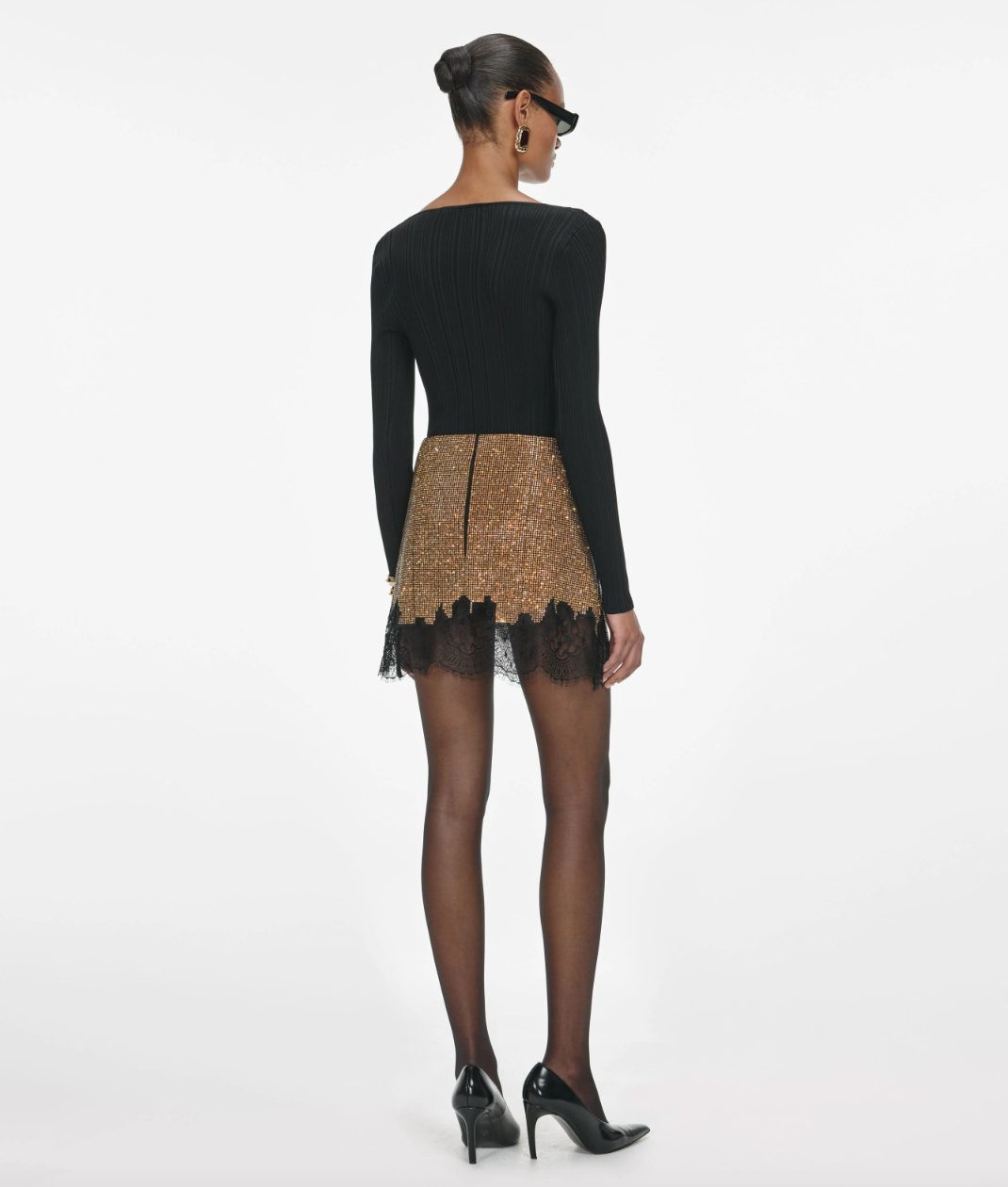 Elevate your evening look with this Brown Crystal Mini Skirt by self-portrait, featuring delicate lace trims that bring a sophisticated boudoir flair. Crafted in a fitted silhouette with minimal stretch, it offers a sleek shape complemented by a convenient back zip closure. The unlined design keeps it light, while the crystal chainmail fabric adds a subtle shimmer. Pair it with a simple tee and flats for effortless date night style, or combine it with the matching top and heels for a striking party ensemble