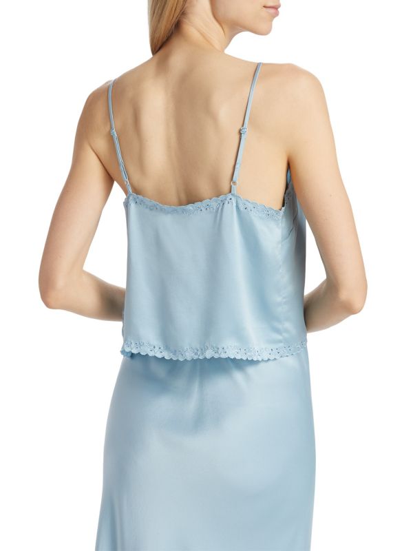 Crafted from 100% luxurious silk, the Elise Silk Crop Camisole by D Ô E N showcases a refined slip silhouette enhanced by openwork front buttons. Its delicate embroidered trim adds subtle elegance to the sleeveless design, while adjustable straps ensure a perfect fit. Featuring a flattering V-neck and tailored button-front closure, this piece combines comfort and sophistication. 