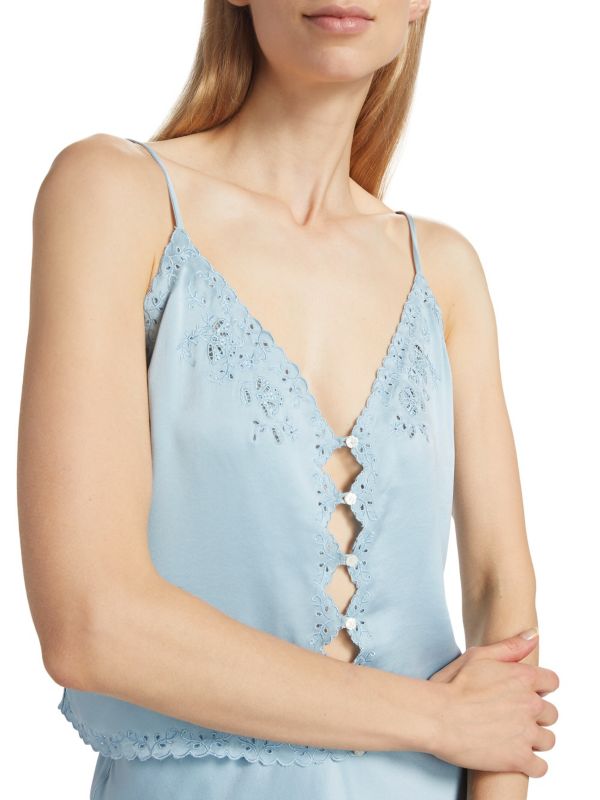 Crafted from 100% luxurious silk, the Elise Silk Crop Camisole by D Ô E N showcases a refined slip silhouette enhanced by openwork front buttons. Its delicate embroidered trim adds subtle elegance to the sleeveless design, while adjustable straps ensure a perfect fit. Featuring a flattering V-neck and tailored button-front closure, this piece combines comfort and sophistication. 