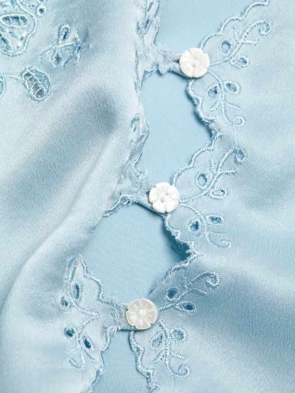 Crafted from 100% luxurious silk, the Elise Silk Crop Camisole by D Ô E N showcases a refined slip silhouette enhanced by openwork front buttons. Its delicate embroidered trim adds subtle elegance to the sleeveless design, while adjustable straps ensure a perfect fit. Featuring a flattering V-neck and tailored button-front closure, this piece combines comfort and sophistication. 
