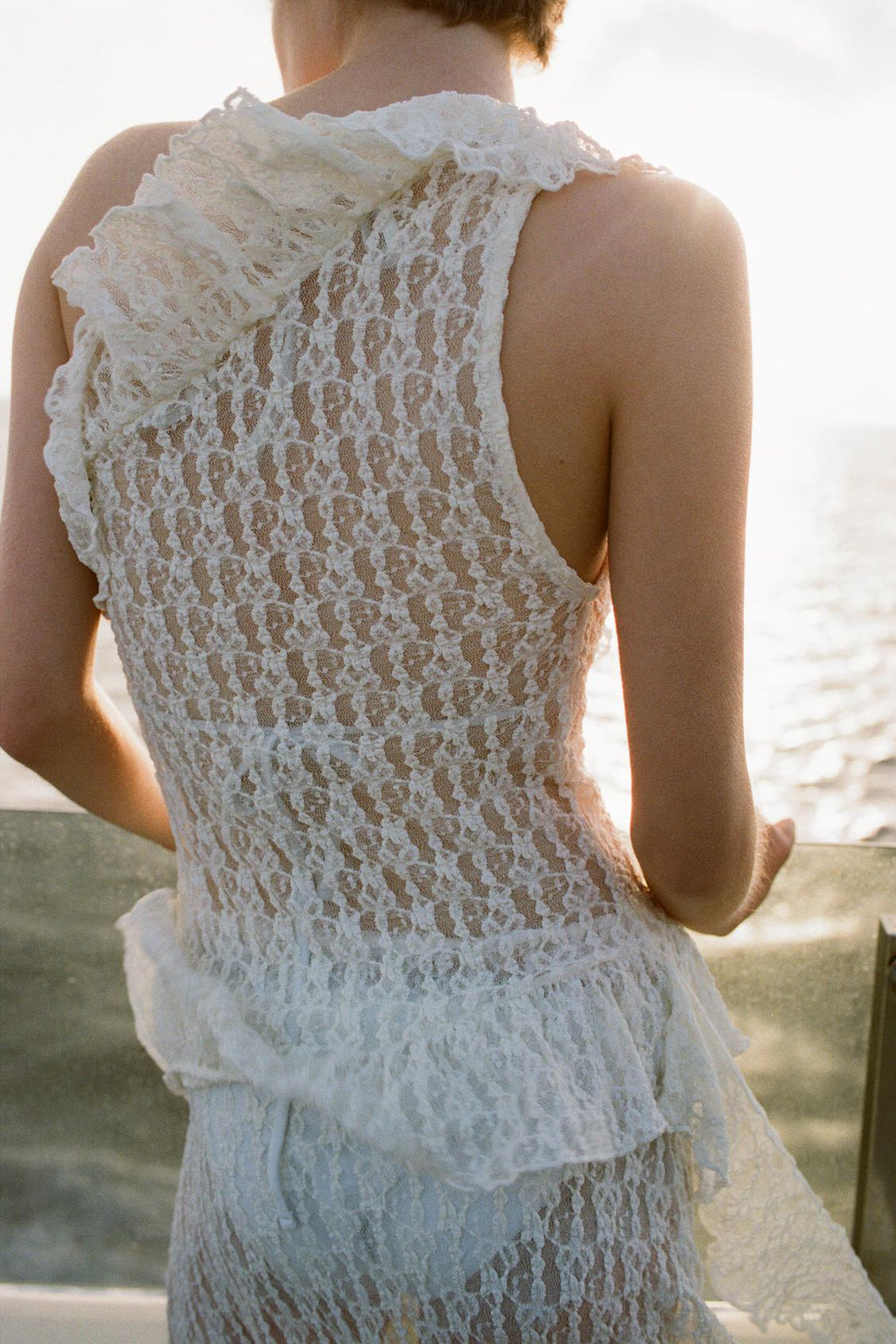 Elevate your wardrobe with the Asymmetric Lace Set, featuring a high-waisted semi-sheer long skirt that offers a comfortable fit with its elastic waistband. The semi-sheer top stands out with an asymmetric neckline and delicate ruffle detailing, adding a refined touch to the ensemble. This set balances elegance and subtle allure, perfect for sophisticated occasions where style and comfort are essential.