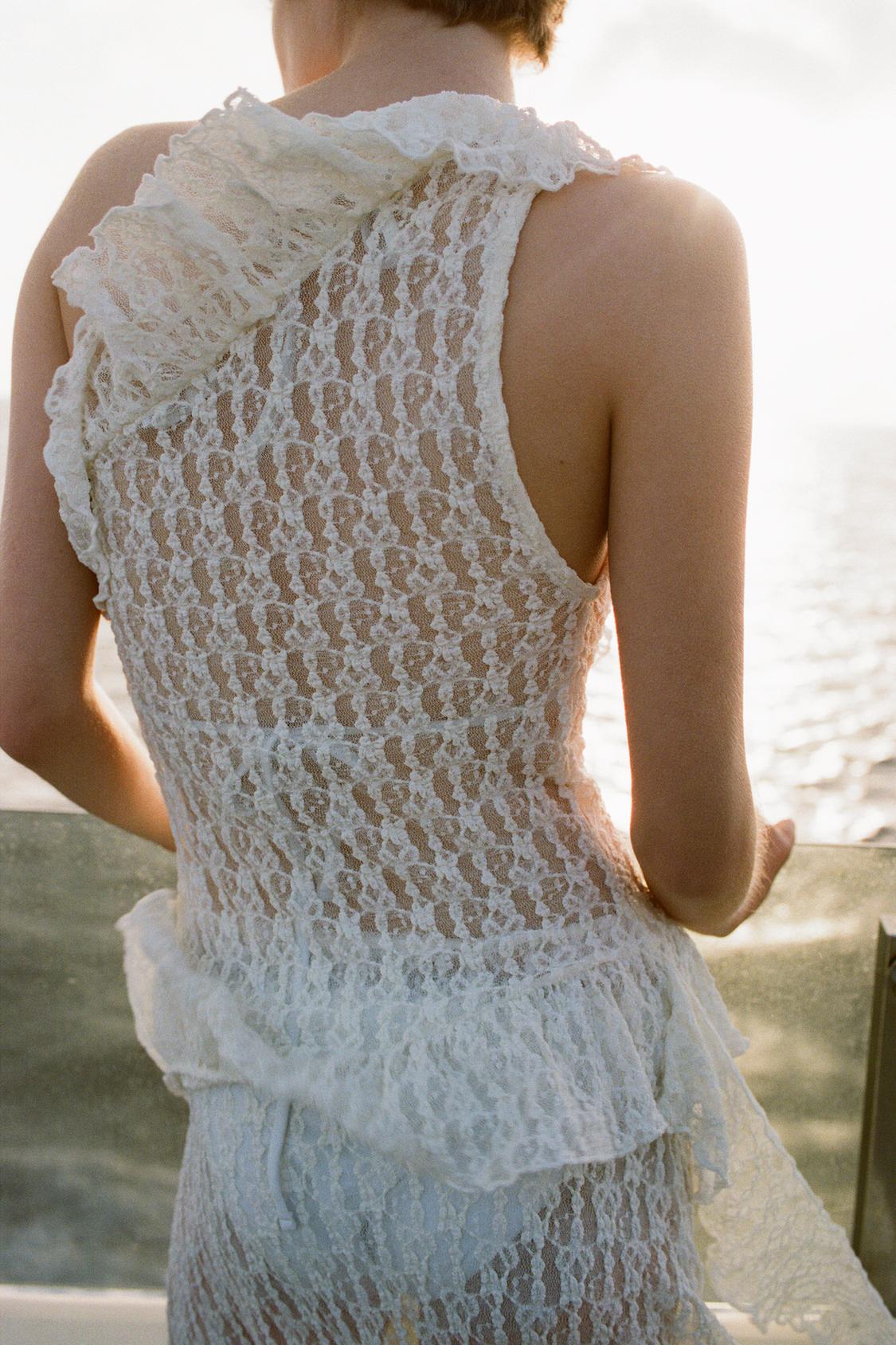 Elevate your wardrobe with the Asymmetric Lace Set, featuring a high-waisted semi-sheer long skirt that offers a comfortable fit with its elastic waistband. The semi-sheer top stands out with an asymmetric neckline and delicate ruffle detailing, adding a refined touch to the ensemble. This set balances elegance and subtle allure, perfect for sophisticated occasions where style and comfort are essential.