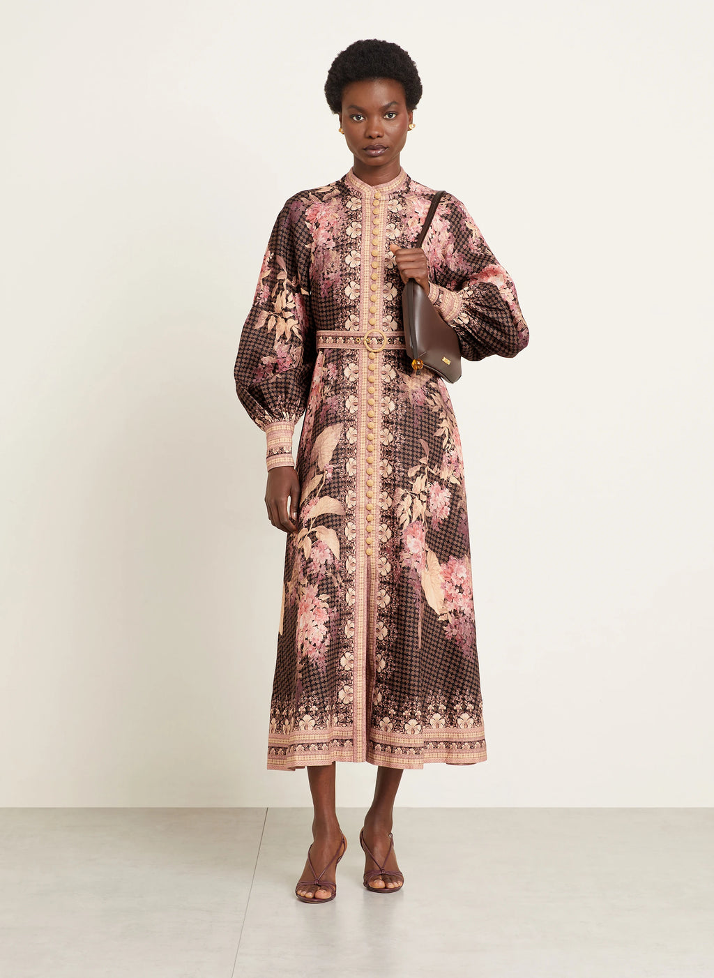 This Illuminate Linen Dress by Zimmermann features a tailored silhouette with a flared skirt, complemented by a stand-up collar and long balloon sleeves. It closes with a refined piped button placket at the front and a discreet invisible zipper at the back, ensuring a seamless fit. The high cuffs are fastened with invisible zippers, adding subtle detail, while a detachable belt with loops enhances the waist definition. 