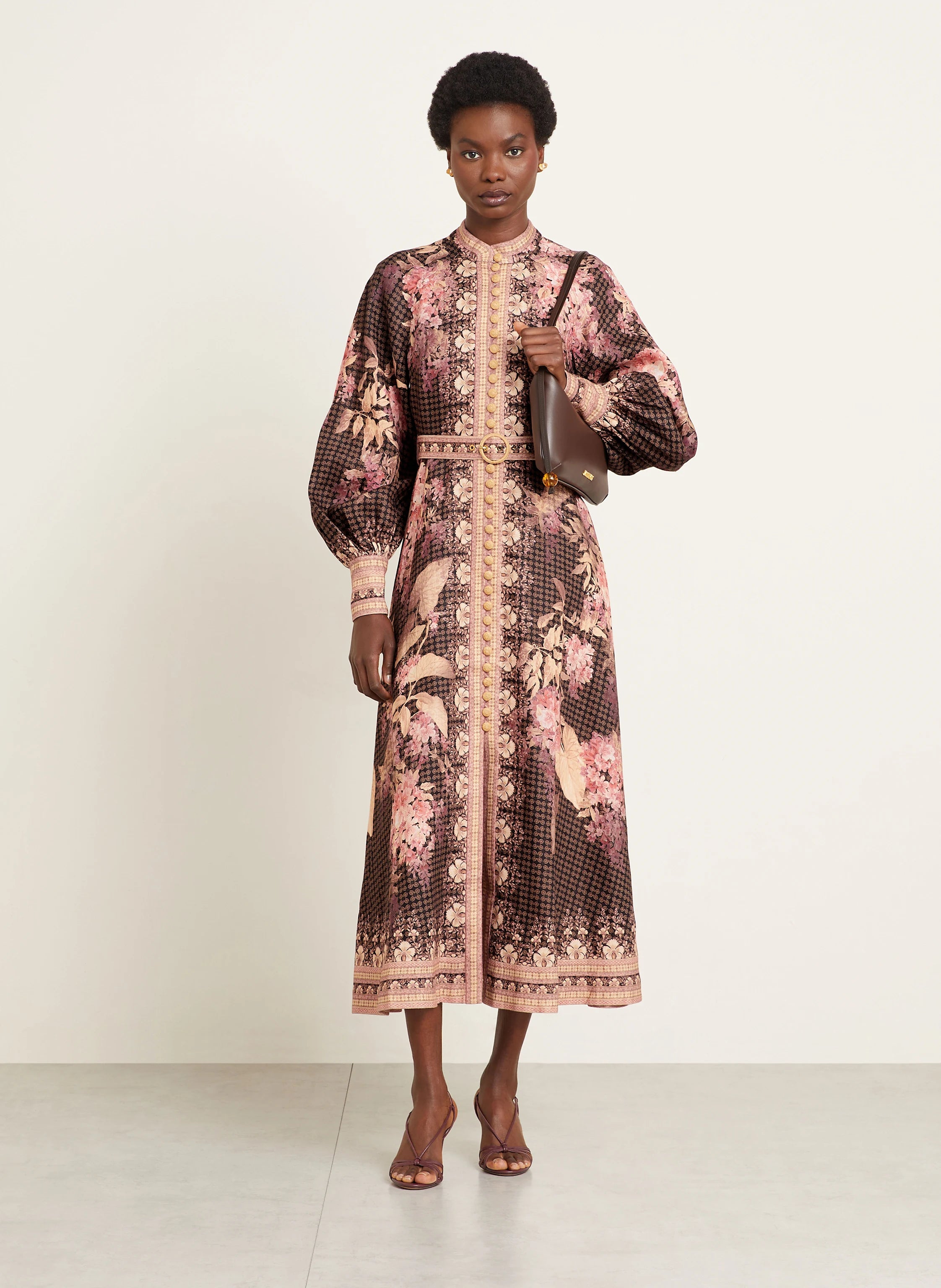 This Illuminate Linen Dress by Zimmermann features a tailored silhouette with a flared skirt, complemented by a stand-up collar and long balloon sleeves. It closes with a refined piped button placket at the front and a discreet invisible zipper at the back, ensuring a seamless fit. The high cuffs are fastened with invisible zippers, adding subtle detail, while a detachable belt with loops enhances the waist definition. 