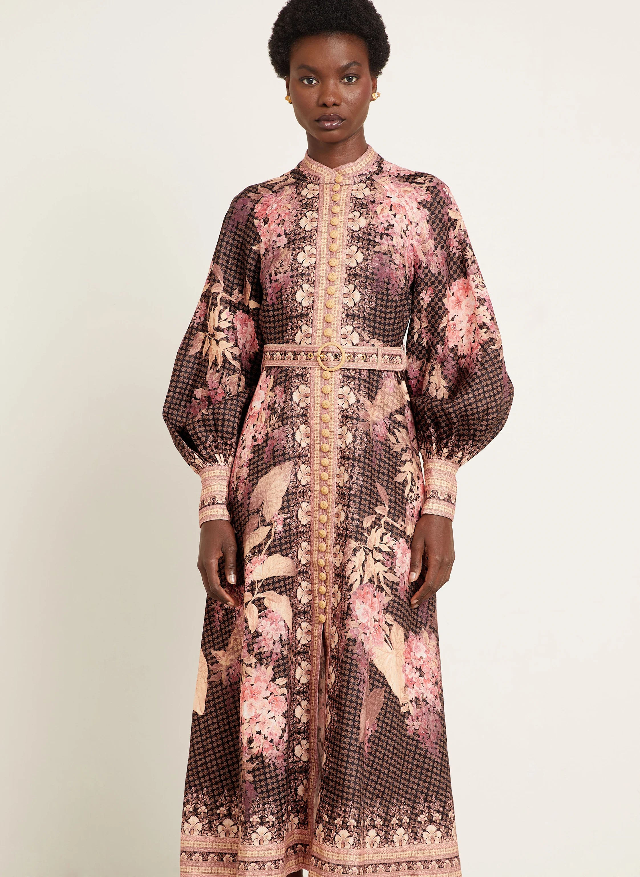 This Illuminate Linen Dress by Zimmermann features a tailored silhouette with a flared skirt, complemented by a stand-up collar and long balloon sleeves. It closes with a refined piped button placket at the front and a discreet invisible zipper at the back, ensuring a seamless fit. The high cuffs are fastened with invisible zippers, adding subtle detail, while a detachable belt with loops enhances the waist definition. 