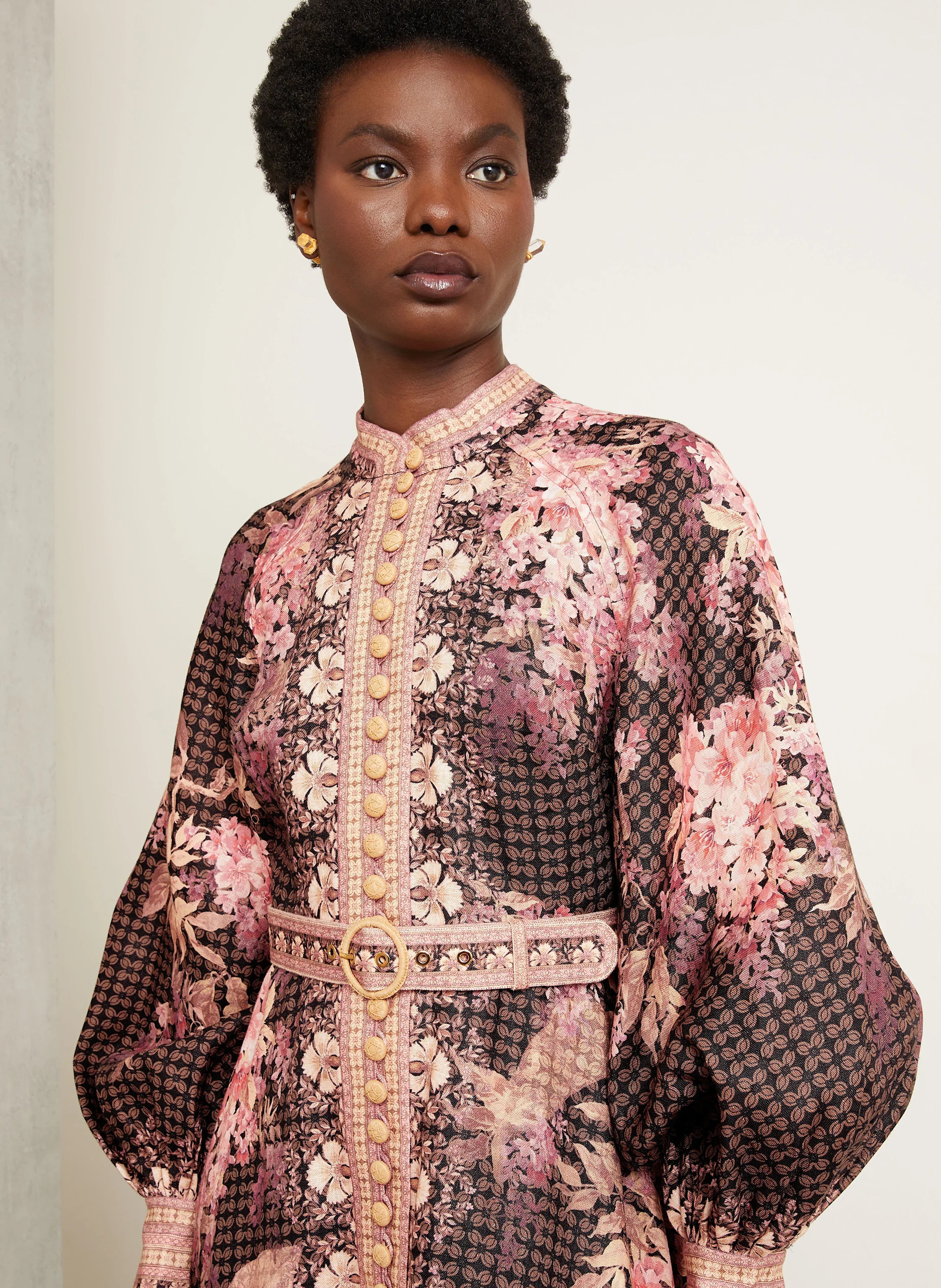 This Illuminate Linen Dress by Zimmermann features a tailored silhouette with a flared skirt, complemented by a stand-up collar and long balloon sleeves. It closes with a refined piped button placket at the front and a discreet invisible zipper at the back, ensuring a seamless fit. The high cuffs are fastened with invisible zippers, adding subtle detail, while a detachable belt with loops enhances the waist definition. 