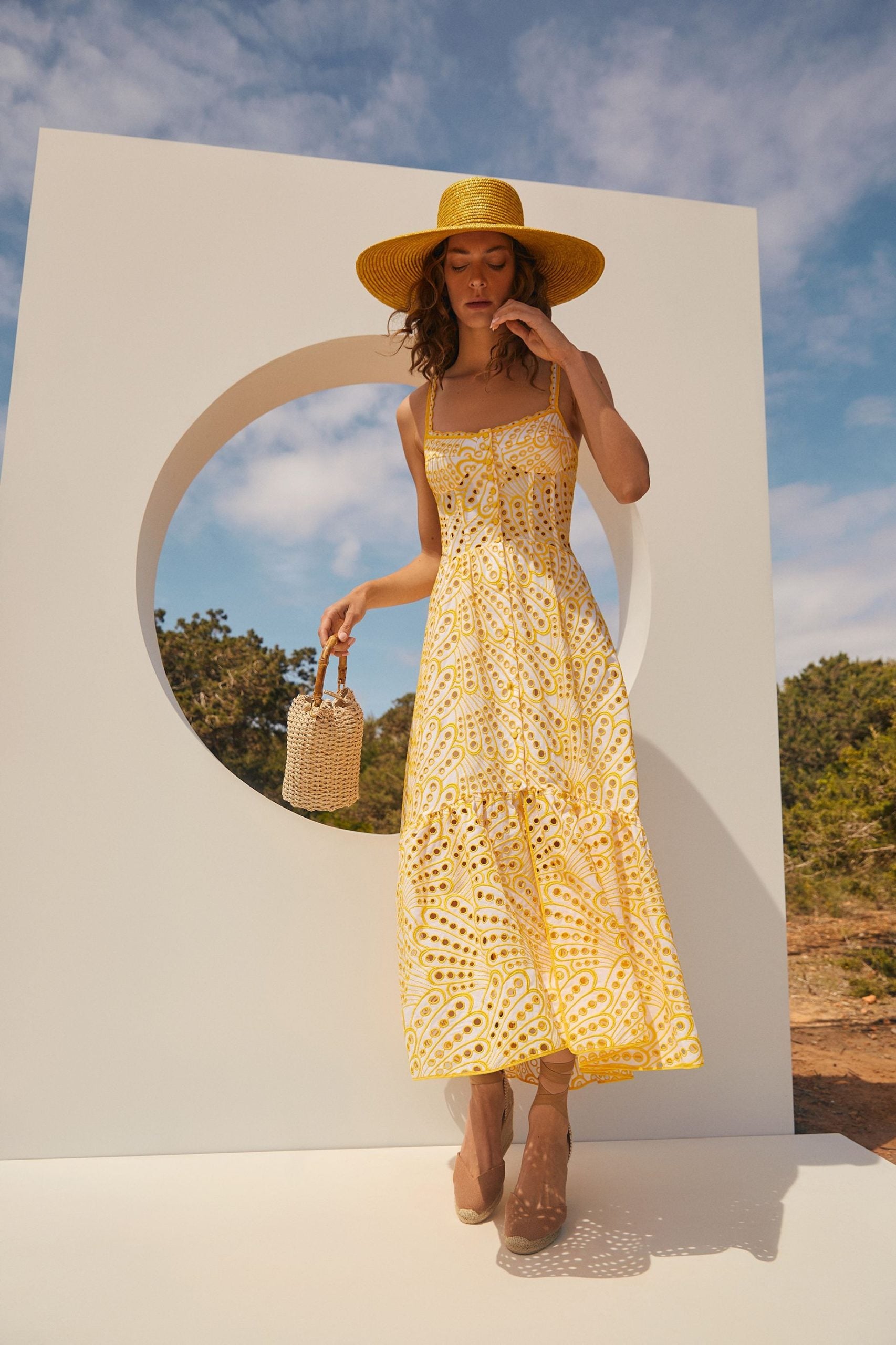 The Irene Dress by Charo Ruiz Ibiza features a front button design that allows for a full opening, enhancing ease and elegance. Crafted from partially lined embroidered batiste, it boasts a corseted bodice with a Balconette neckline that sculpts the silhouette. The dress culminates in a striking skirt, flowing into a dramatic ruffle made from the same delicate openwork fabric, combining structure with a graceful, airy finish.