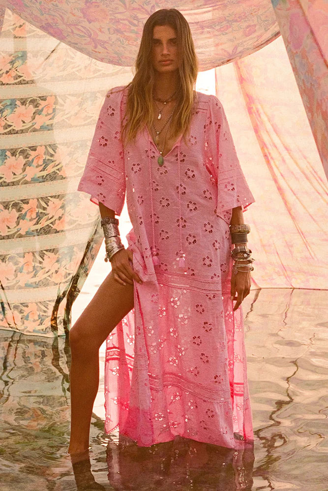 Step into a daydream with the Love Note Broderie Gown in Cosmos Pink, a gown that speaks of romance and delicate femininity. The soft pink hue, combined with custom embroidery and lace, lends an air of whimsy and beauty. A V-neckline with a keyhole opening at the centre front and side splits create a graceful, flowing silhouette, while flutter sleeves add a touch of fairytale magic. 