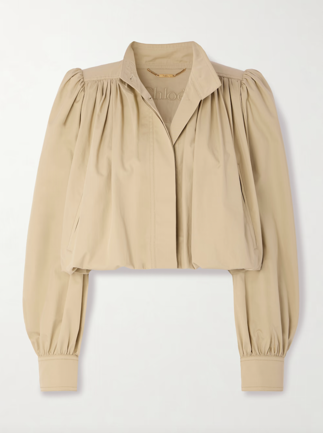 Chloé’s gathered cotton-twill jacket features a distinctive bubble hem and delicate gathers at the yoke and shoulders, offering a structured yet softly voluminous silhouette. Crafted from breathable cotton twill, it balances comfort with sophisticated tailoring. Ideal for layering, pair it with high-rise jeans and layered jewelry to channel the refined ease of the Spring ’25 runway. This jacket merges modern design with timeless wearability for a standout, expert-level addition to your wardrobe.