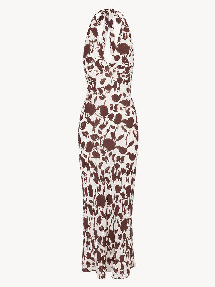 The Simone in Chocolate Havana offers an ankle-length silhouette that flatters with a captivating bust line, perfect for embracing late summer elegance. Crafted from smooth silk in a timeless chocolate brown and white Havana print, this dress requires minimal styling—no bra needed. Whether worn with hair up or down, its effortless charm is complemented by subtle jewelry. Experience an endless summer escape in the refined yet relaxed design of the Simone.