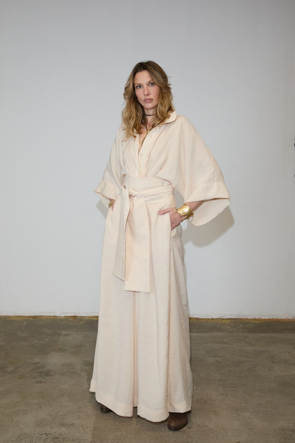 The Lauren Jumpsuit embodies refined sophistication with its architectural kimono sleeves and tailored waist, creating a striking wide-leg silhouette that merges bold design with effortless movement. Made from a breathable viscose blend, it offers a soft, flowing drape complemented by a sharp collar and a sculptural belt that defines the waist. This versatile piece transitions seamlessly from relaxed mornings to commanding appearances, reflecting timeless style and expert craftsmanship.