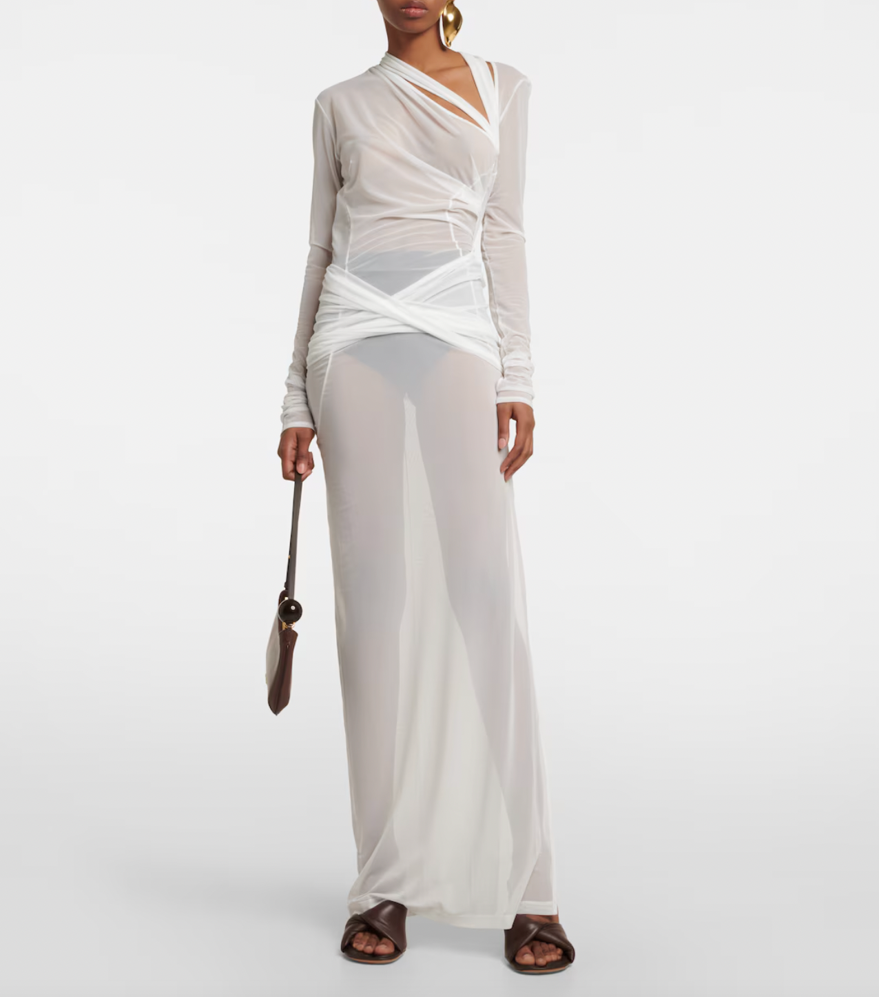 The La Robe Piombone tulle maxi dress by Jacquemus showcases a refined sheer tulle construction with a draped, full-length silhouette that elegantly contours the body. Its asymmetric neckline adds a modern architectural touch, while the long sleeves with thumb holes provide subtle coverage and a distinctive detail. The high-cut side slit enhances movement and introduces a sensual element, making this dress a sophisticated statement for formal occasions or avant-garde styling.