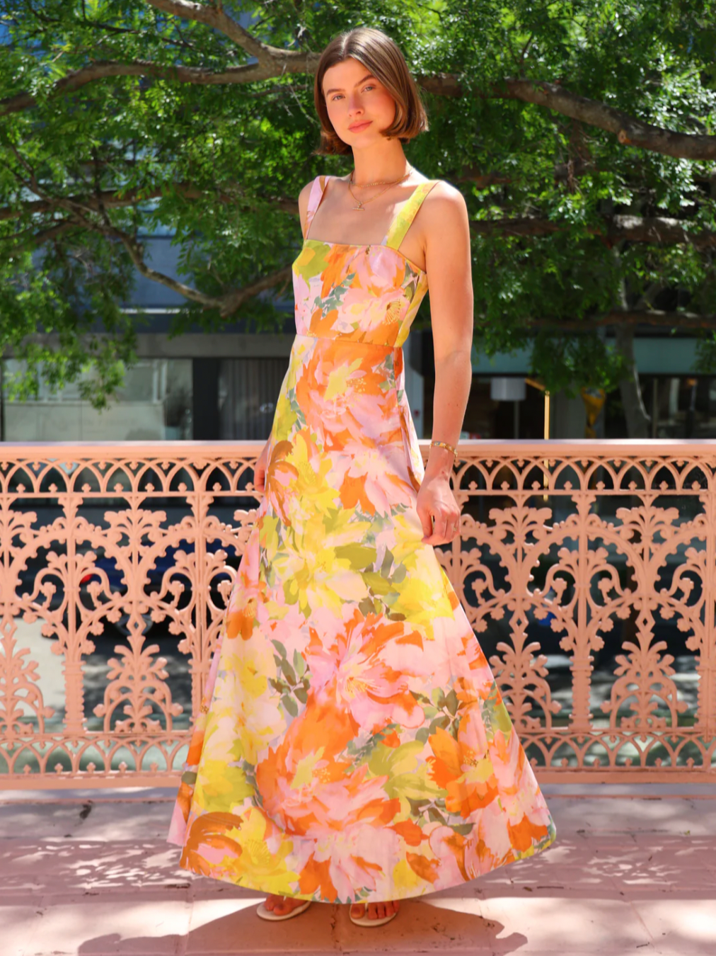 The Goldie Maxi Dress in Floral Confetti by Nicola offers a refined silhouette with a fully lined design and elegant circle skirt for graceful movement. Its wide straps and straight neckline highlight a flattering shape, while the delicate floral confetti pattern adds a soft, romantic touch. Finished with a discreet center-back zip, this dress ensures a seamless fit, making it an ideal choice for garden parties, weddings, or any event where effortless elegance is desired. 
