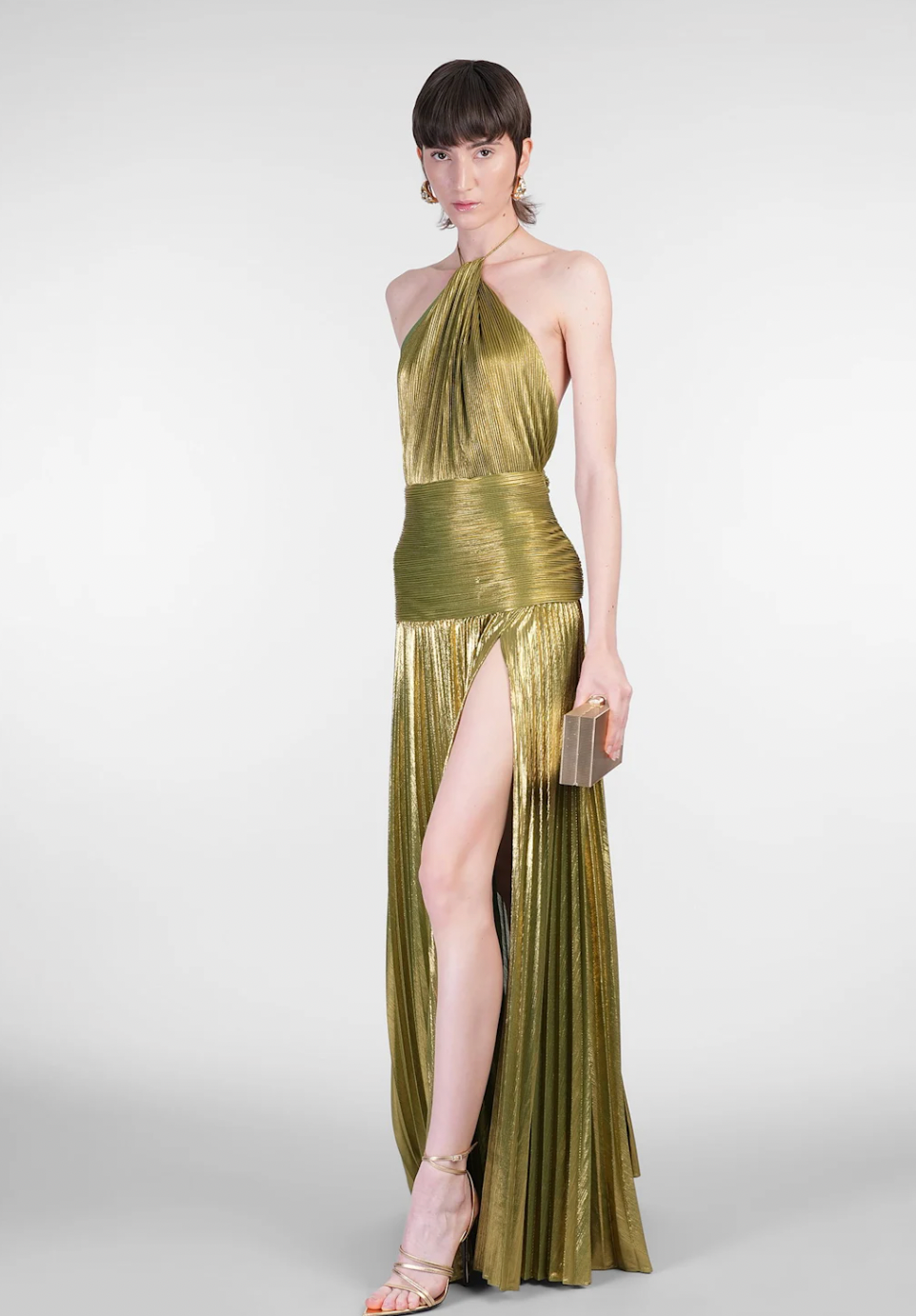 The Thalia Dress by Retrofete showcases pleated satin that shimmers with every movement. Its halterneck tie-up closure and concealed back zipper deliver a tailored fit, complemented by an open back that exudes refined allure. Partially lined for comfort and featuring a front slit, this dress balances elegance with ease of wear, making it a sophisticated choice for any upscale event.