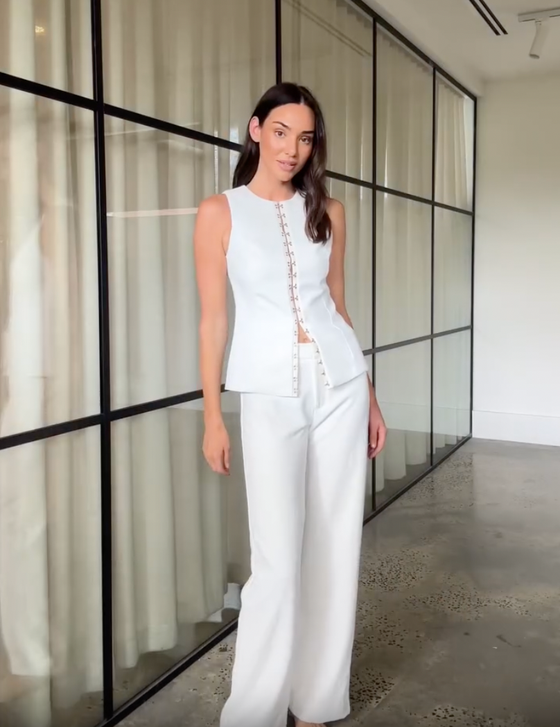 Introducing the Oyster Hook Crew Top, designed to make a statement. Crafted from suiting fabrication. The silhouette features an elegant high neckline and subtly flared hemline. Along with gold hook and eye details that can be adjusted for self styling.