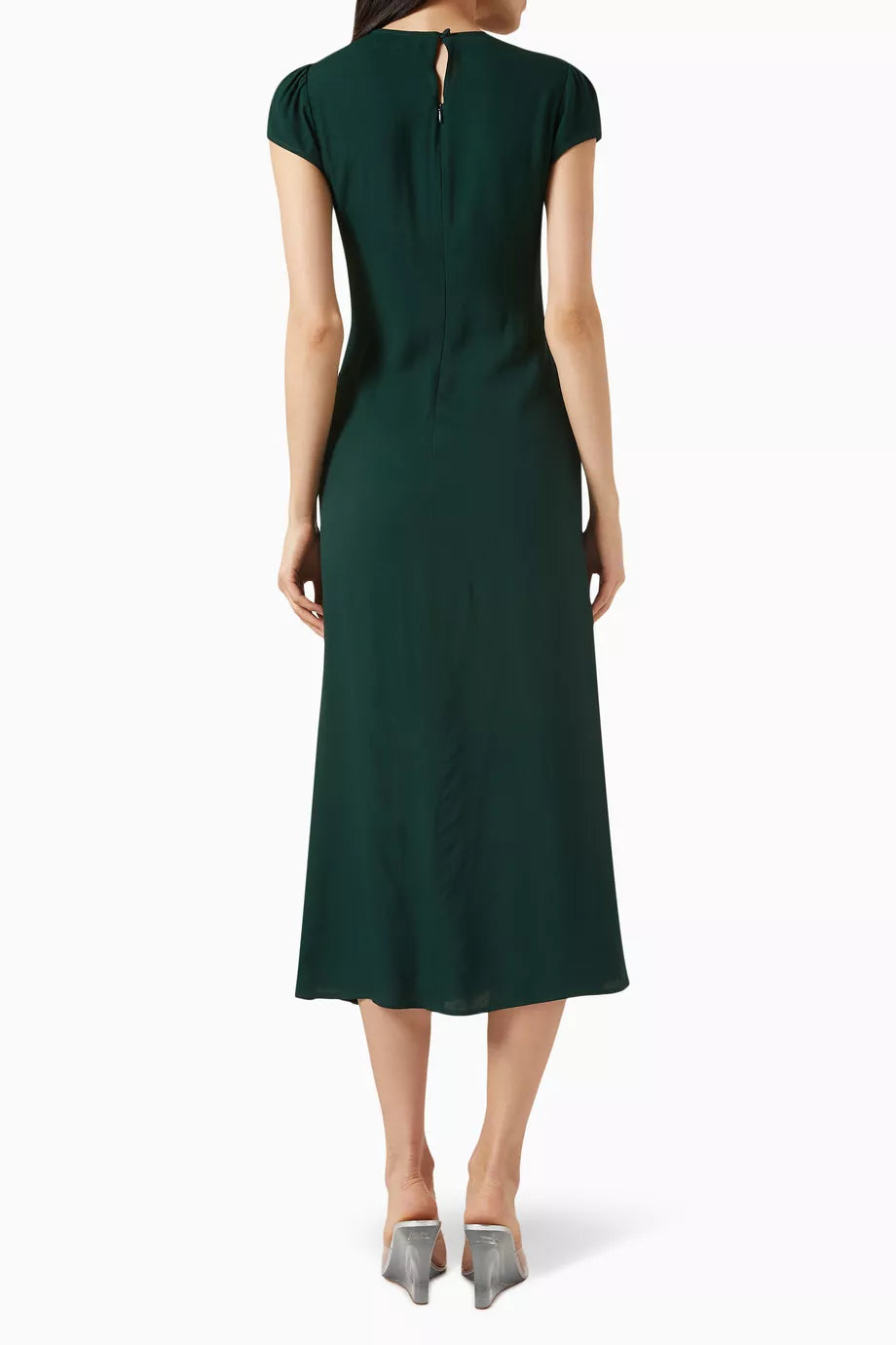 The Frasier Dress by Reformation, crafted in Los Angeles, embodies sustainable sophistication. Its crew neckline and cap sleeves frame a sleek slim silhouette enhanced by an off-center button detail. The high slit adds refined modernity, balancing style and eco-conscious design. This midi dress is perfect for those who demand elegance while supporting responsible fashion.
