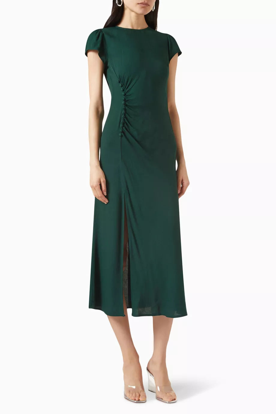 The Frasier Dress by Reformation, crafted in Los Angeles, embodies sustainable sophistication. Its crew neckline and cap sleeves frame a sleek slim silhouette enhanced by an off-center button detail. The high slit adds refined modernity, balancing style and eco-conscious design. This midi dress is perfect for those who demand elegance while supporting responsible fashion.