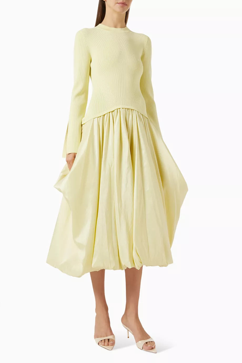 The Kenlie Midi Dress in Rayon Blend by Simkhai offers a sleek minimalist design that expertly enhances your silhouette. Its stretchy knit top contours comfortably, while the A-line skirt creates an elegant hourglass shape. Versatile by nature, this dress seamlessly transitions from casual to refined occasions, delivering both comfort and sophistication with ease.