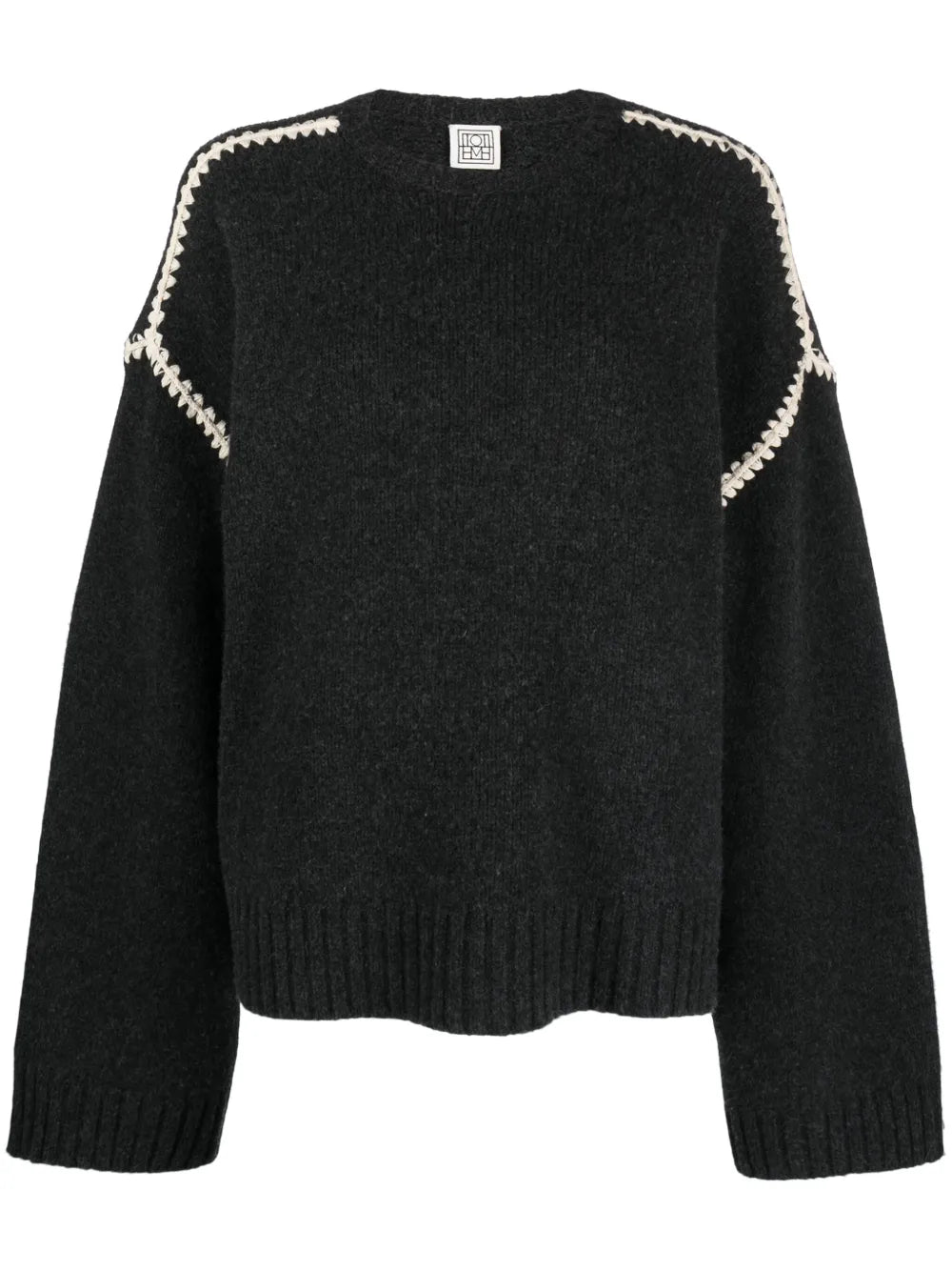 This TOTEME embroidered wool jumper combines minimalist design with luxurious craftsmanship. Made in Italy from high-quality wool, it features a subtle mélange effect in anthracite grey, highlighted by contrasting white whipstitch detailing. The knitted construction offers warmth and durability, while the crew neck, drop shoulders, and ribbed cuffs and hem provide a refined fit and comfortable wear. Ideal for layering or as a statement piece, this jumper balances understated elegance with standout details.