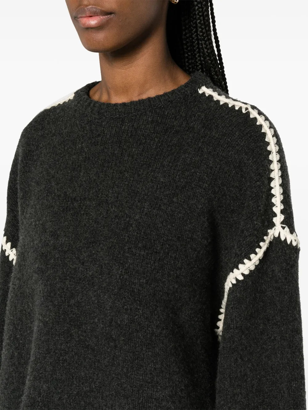 This TOTEME embroidered wool jumper combines minimalist design with luxurious craftsmanship. Made in Italy from high-quality wool, it features a subtle mélange effect in anthracite grey, highlighted by contrasting white whipstitch detailing. The knitted construction offers warmth and durability, while the crew neck, drop shoulders, and ribbed cuffs and hem provide a refined fit and comfortable wear. Ideal for layering or as a statement piece, this jumper balances understated elegance with standout details.