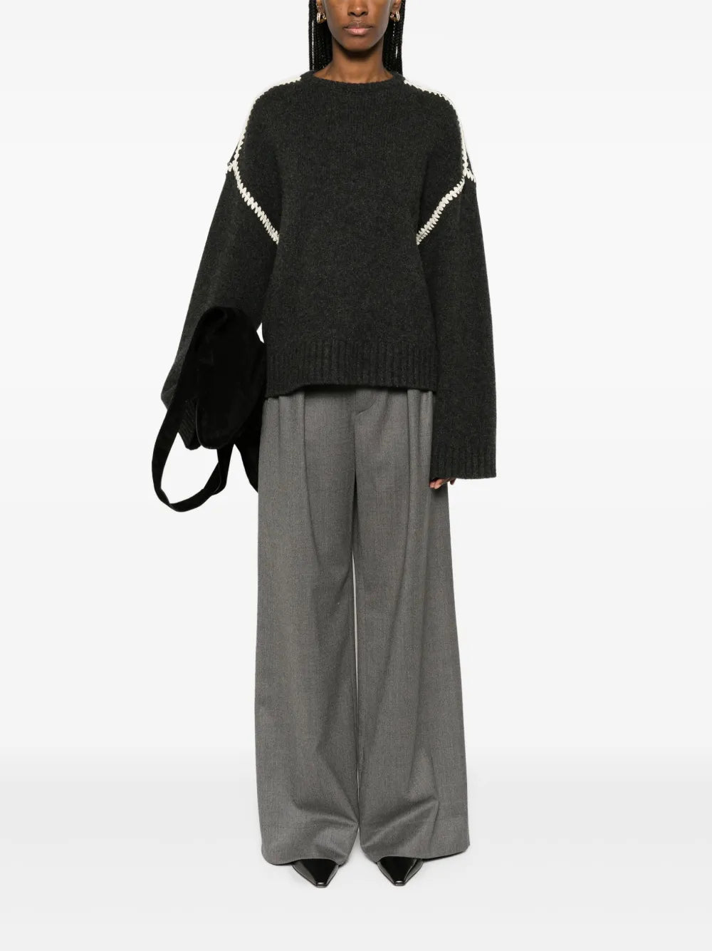 This TOTEME embroidered wool jumper combines minimalist design with luxurious craftsmanship. Made in Italy from high-quality wool, it features a subtle mélange effect in anthracite grey, highlighted by contrasting white whipstitch detailing. The knitted construction offers warmth and durability, while the crew neck, drop shoulders, and ribbed cuffs and hem provide a refined fit and comfortable wear. Ideal for layering or as a statement piece, this jumper balances understated elegance with standout details.