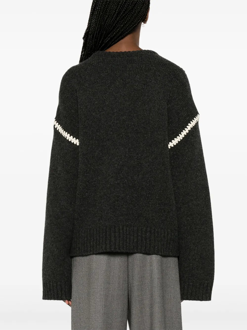 This TOTEME embroidered wool jumper combines minimalist design with luxurious craftsmanship. Made in Italy from high-quality wool, it features a subtle mélange effect in anthracite grey, highlighted by contrasting white whipstitch detailing. The knitted construction offers warmth and durability, while the crew neck, drop shoulders, and ribbed cuffs and hem provide a refined fit and comfortable wear. Ideal for layering or as a statement piece, this jumper balances understated elegance with standout details.