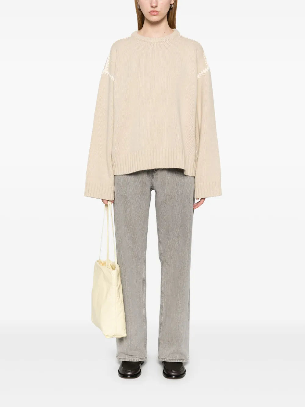 This embroidered wool jumper by Toteme combines minimalist design with luxurious craftsmanship. Made in Italy from high-quality wool, it features a subtle mélange effect in anthracite grey, highlighted by contrasting white whipstitch detailing. The knitted construction offers warmth and durability, while the crew neck, drop shoulders, and ribbed cuffs and hem provide a refined fit and comfortable wear. 