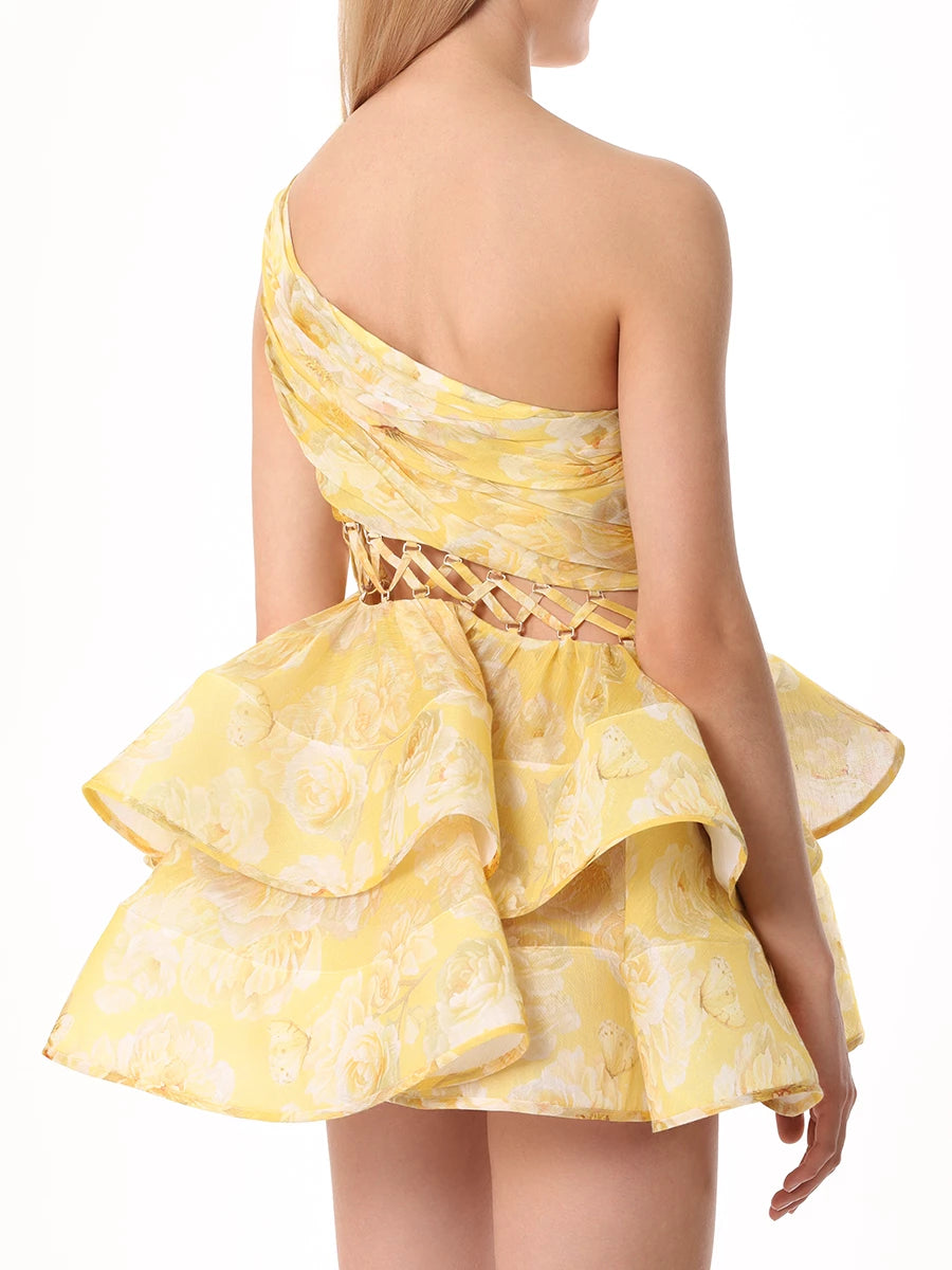 The Iris Dress by YVON is crafted from premium linen silk, showcasing an elegant yellow blend with a floral print inspired by fairy forest blossoms. Its handmade asymmetrical bodice defines femininity with subtle allure, while the waist lacing sculpts a striking silhouette. This dress balances romantic charm with sophisticated design for a truly unique statement piece.