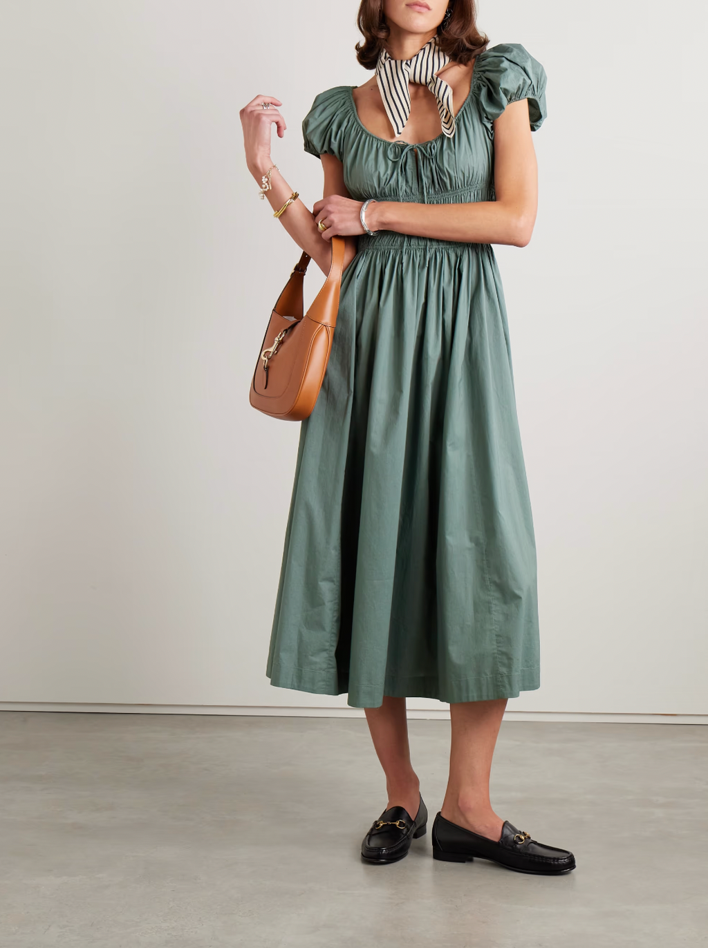 Crafted from organic cotton-poplin, the Quinn midi dress by Doen combines sustainable fabric with expert tailoring. Its shirred bodice and tie detailing create a flattering fit, enhancing natural curves while providing comfort. This versatile piece seamlessly transitions from day to evening, reflecting thoughtful design and eco-conscious materials in a refined silhouette.