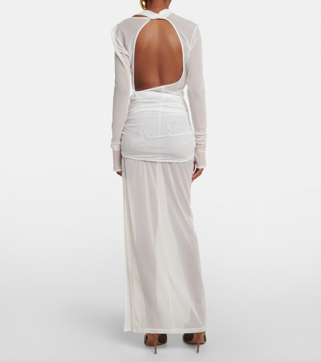 The La Robe Piombone tulle maxi dress by Jacquemus showcases a refined sheer tulle construction with a draped, full-length silhouette that elegantly contours the body. Its asymmetric neckline adds a modern architectural touch, while the long sleeves with thumb holes provide subtle coverage and a distinctive detail. The high-cut side slit enhances movement and introduces a sensual element, making this dress a sophisticated statement for formal occasions or avant-garde styling.