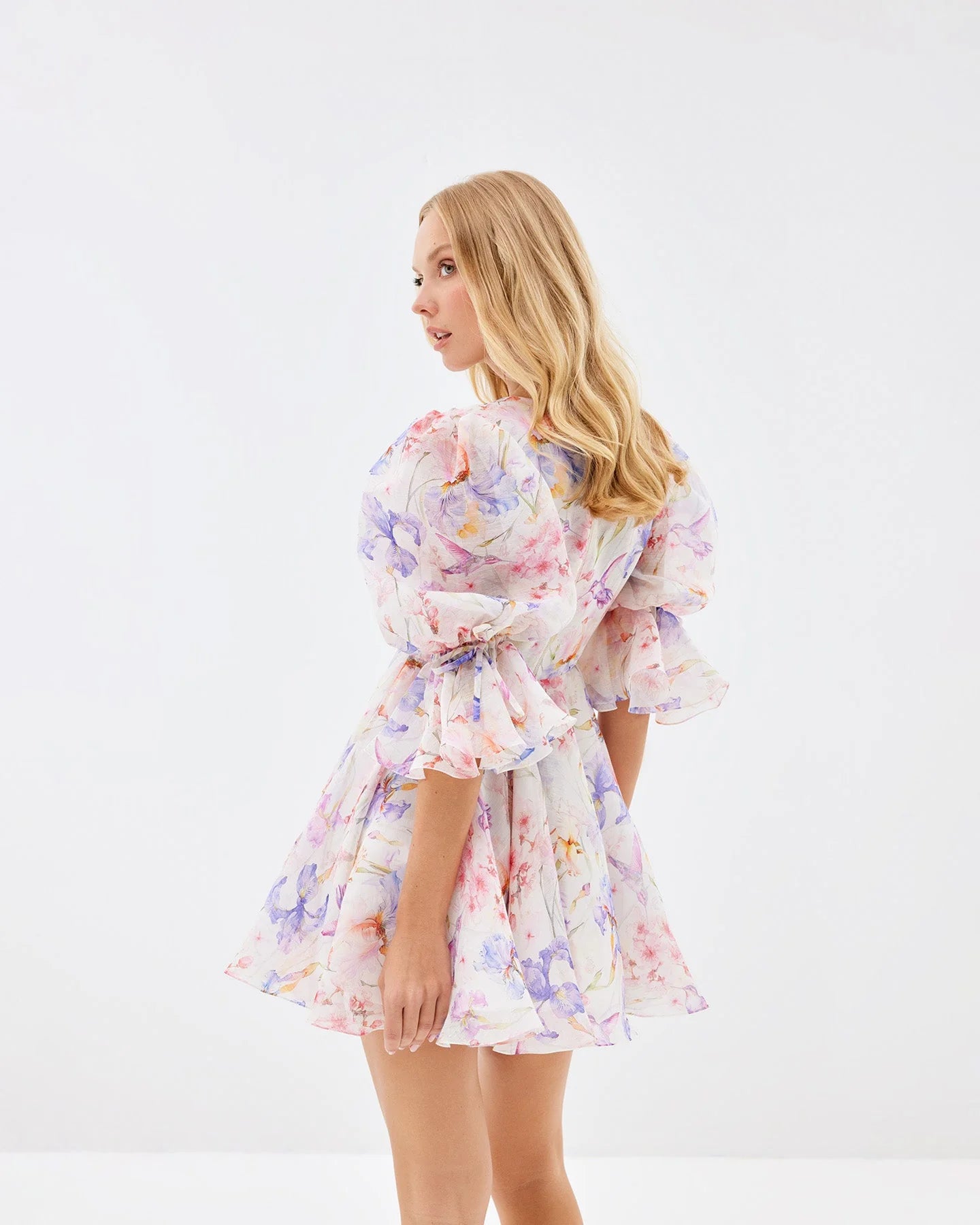 The Fairy Fizz Petals Dress combines romantic design with refined craftsmanship. Its plunging neckline is softly framed by delicate ruffles, while voluminous puff sleeves introduce a playful yet sophisticated flair. The fitted waist enhances your silhouette, perfectly complementing the flowing, flared skirt that moves gracefully. Designed for garden parties and elegant occasions, this dress offers both timeless charm and a captivating presence.