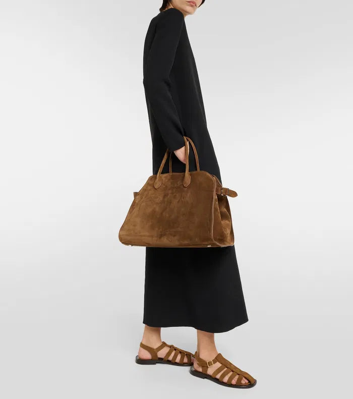 The Soft Margaux 15 Suede Tote Bag by The Row features a softly structured design crafted from supple calfskin suede, offering both elegance and durability. Its belted gusseted side panels provide a refined silhouette while allowing flexible storage capacity. Inside, the spacious interior is thoughtfully designed for organization, making it ideal for daily use with a sophisticated touch.