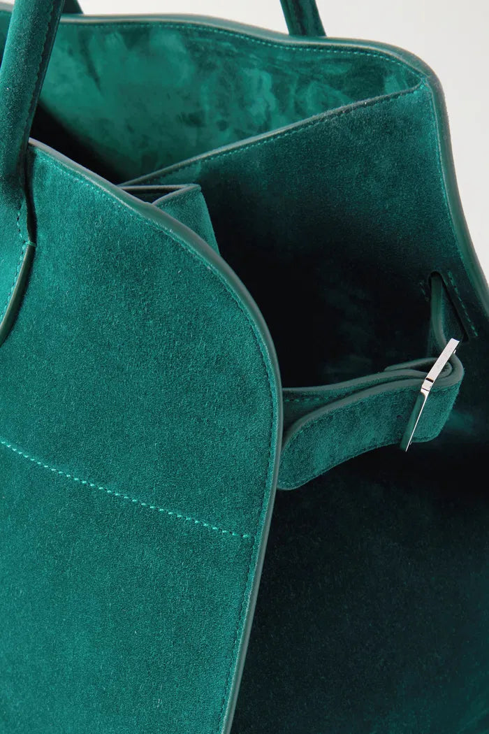 Crafted in Italy from smooth suede, the Margaux Air Suede Tote by The Row offers a softly structured silhouette enhanced by adjustable buckled sides for a customizable fit. Its thoughtful interior pockets provide secure storage for your essentials, merging elegant design with practical functionality. Made from 100% leather, this tote combines refined craftsmanship with everyday utility.