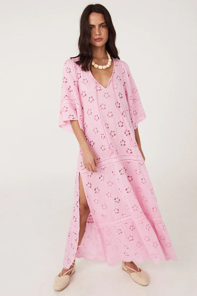 Step into a daydream with the Love Note Broderie Gown in Cosmos Pink, a gown that speaks of romance and delicate femininity. The soft pink hue, combined with custom embroidery and lace, lends an air of whimsy and beauty. A V-neckline with a keyhole opening at the centre front and side splits create a graceful, flowing silhouette, while flutter sleeves add a touch of fairytale magic. 