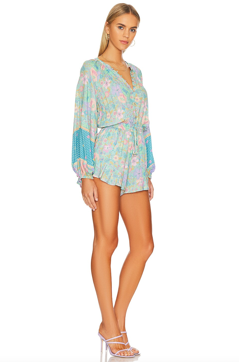 The Hibiscus Lane Romper by Spell features a smocked waistband with a drawstring closure for a tailored fit. Its partial front loop button closure enhances ease of wear, while blouson sleeves with elastic cuffs provide both style and comfort. Crafted from lightweight jersey fabric, this romper offers breathability and a soft, flexible feel, perfect for all-day wear with a polished look.