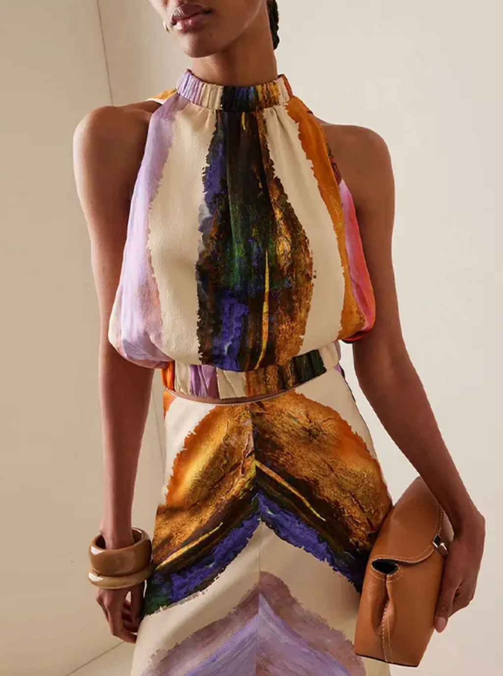 This standout set includes a sleeveless crop top with a halter design that leaves the back exposed, combined with a high-waisted maxi skirt with a modern print. The elongated skirt stylizes the figure, while the top provides a feeling of freshness and sophistication, perfect for summer occasions and casual events with an elegant touch. Its balance between comfort and trend makes this set an ideal choice for those looking for a contemporary and refined look.