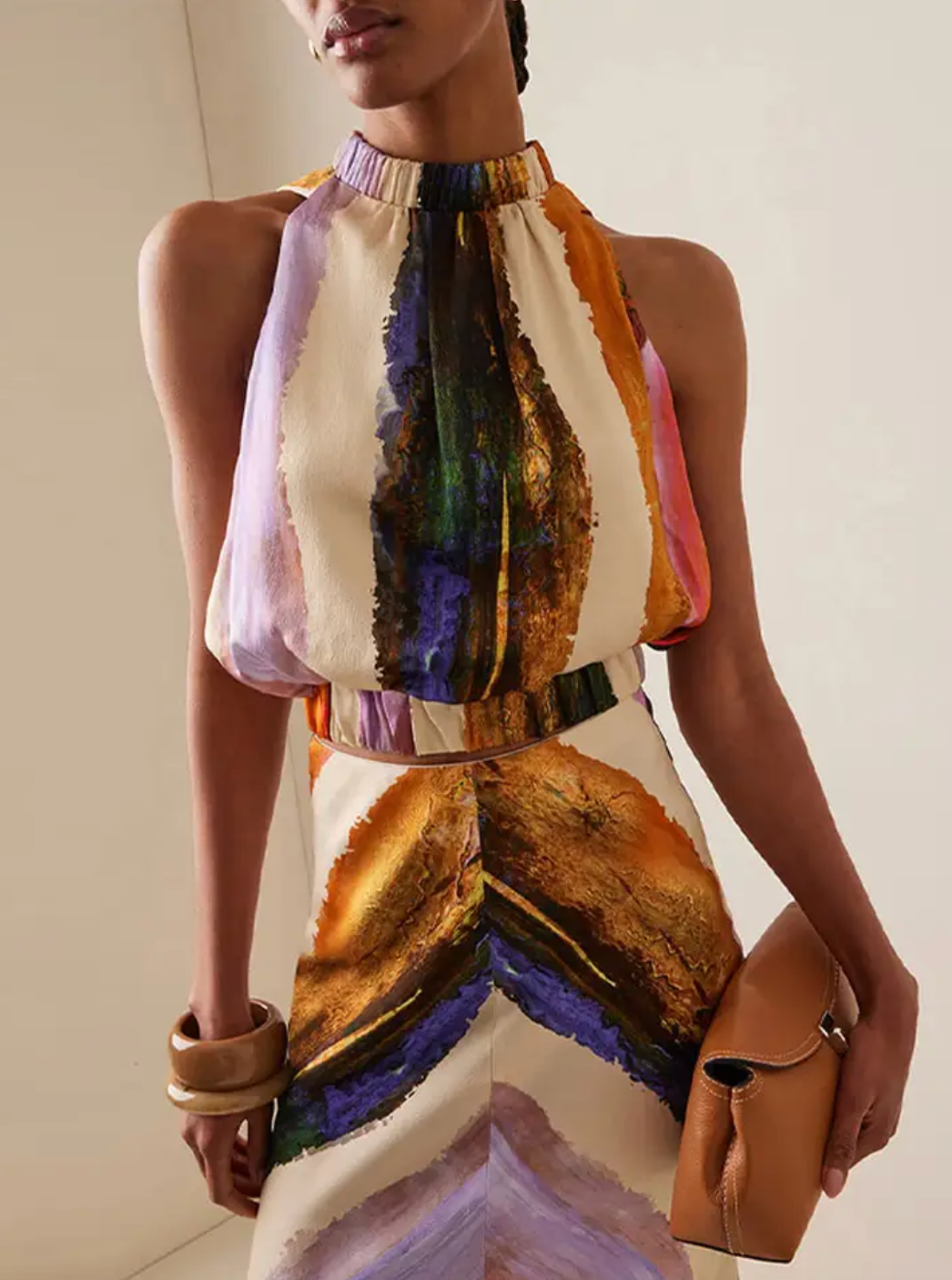 This standout set includes a sleeveless crop top with a halter design that leaves the back exposed, combined with a high-waisted maxi skirt with a modern print. The elongated skirt stylizes the figure, while the top provides a feeling of freshness and sophistication, perfect for summer occasions and casual events with an elegant touch. Its balance between comfort and trend makes this set an ideal choice for those looking for a contemporary and refined look.