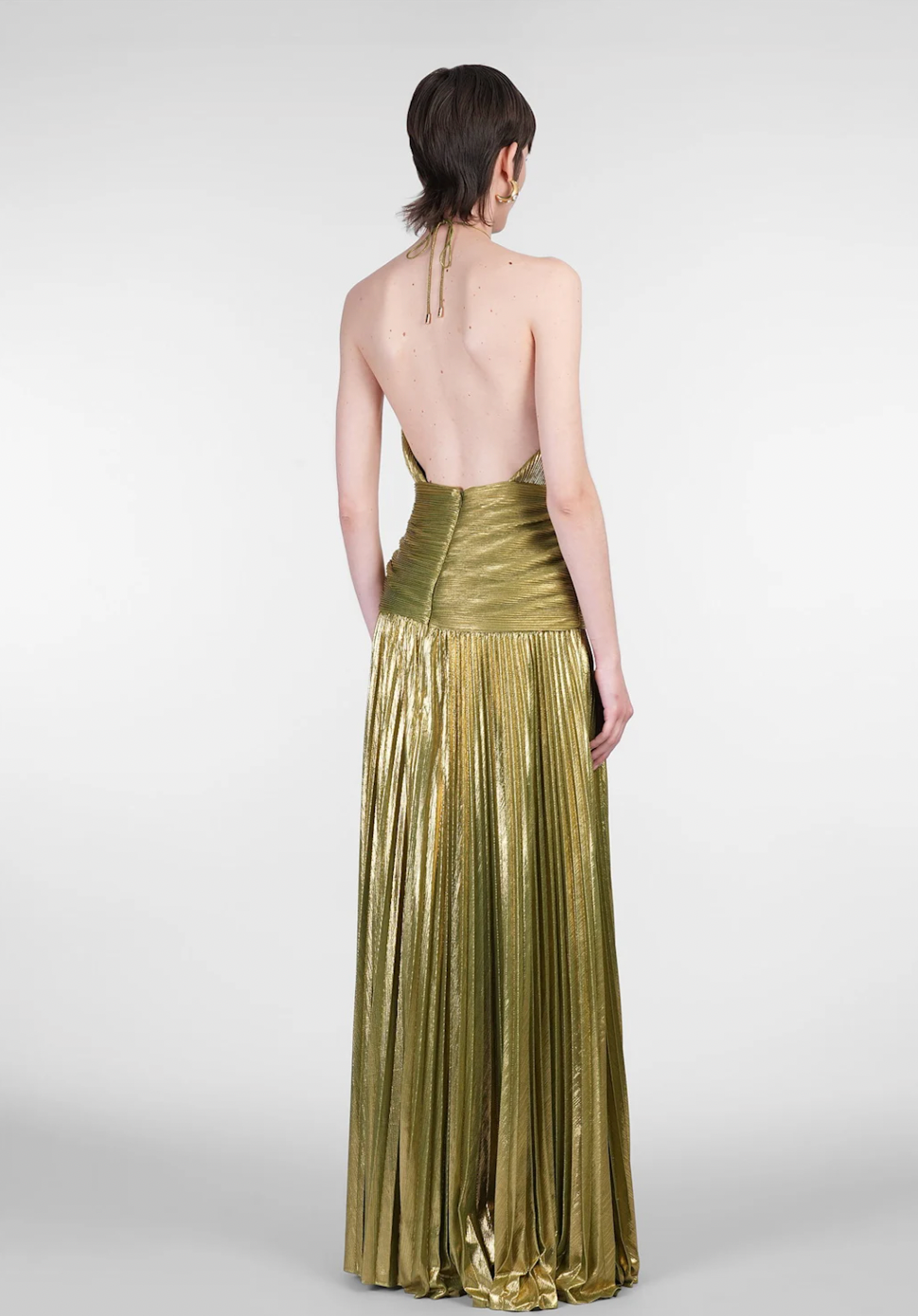 The Thalia Dress by Retrofete showcases pleated satin that shimmers with every movement. Its halterneck tie-up closure and concealed back zipper deliver a tailored fit, complemented by an open back that exudes refined allure. Partially lined for comfort and featuring a front slit, this dress balances elegance with ease of wear, making it a sophisticated choice for any upscale event.