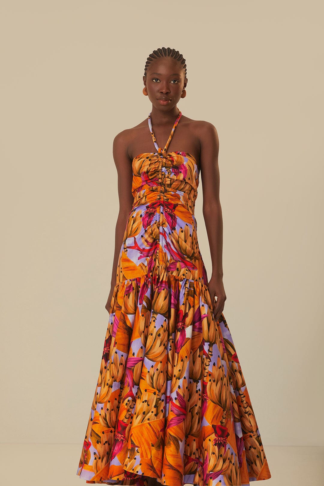 Elevate your style with the Lilac Banana Forest Maxi Dress by FARM Rio. Made from 100% certified organic cotton, this dress features a halter neckline and flowy silhouette, adorned with a charming banana forest print. Sustainable and soft to the touch, it's perfect for any occasion.