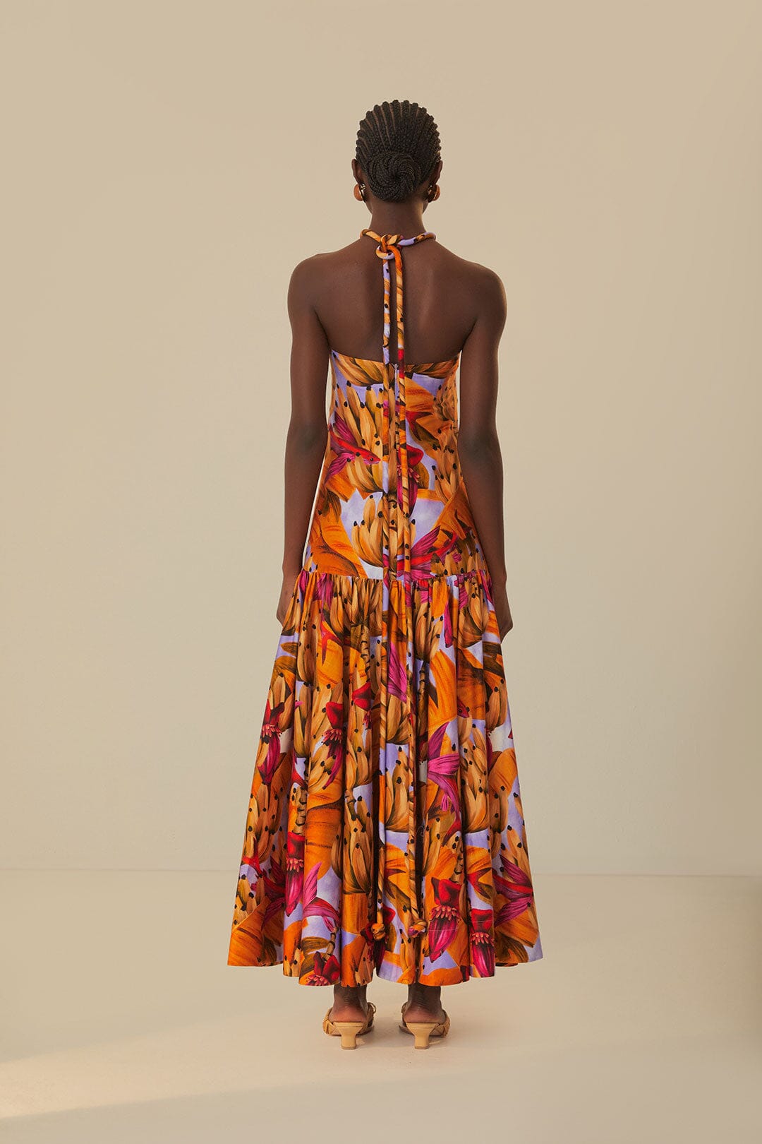 Elevate your style with the Lilac Banana Forest Maxi Dress by FARM Rio. Made from 100% certified organic cotton, this dress features a halter neckline and flowy silhouette, adorned with a charming banana forest print. Sustainable and soft to the touch, it's perfect for any occasion.