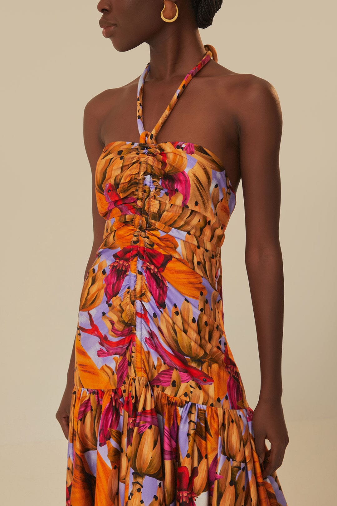 Elevate your style with the Lilac Banana Forest Maxi Dress by FARM Rio. Made from 100% certified organic cotton, this dress features a halter neckline and flowy silhouette, adorned with a charming banana forest print. Sustainable and soft to the touch, it's perfect for any occasion.