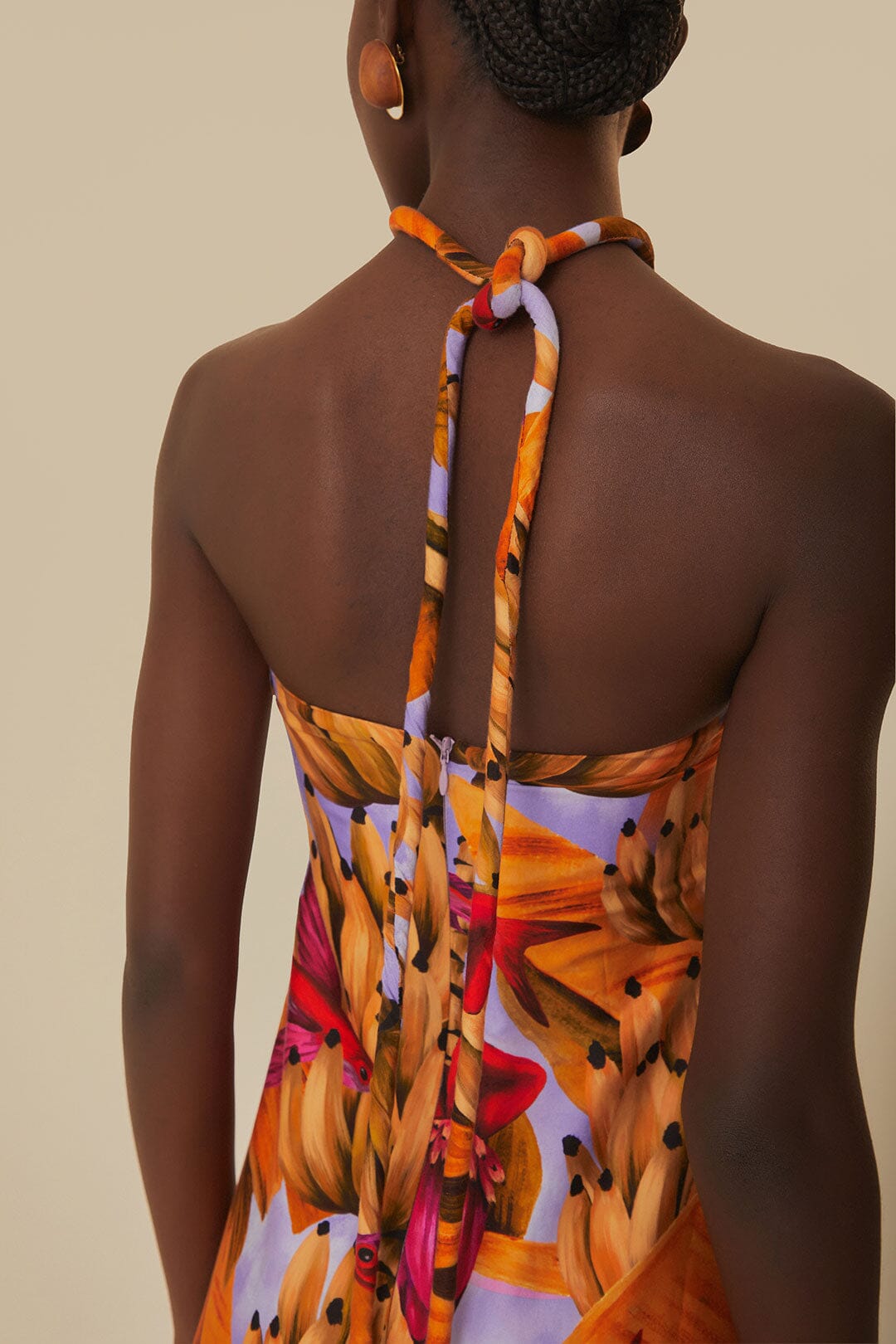 Elevate your style with the Lilac Banana Forest Maxi Dress by FARM Rio. Made from 100% certified organic cotton, this dress features a halter neckline and flowy silhouette, adorned with a charming banana forest print. Sustainable and soft to the touch, it's perfect for any occasion.